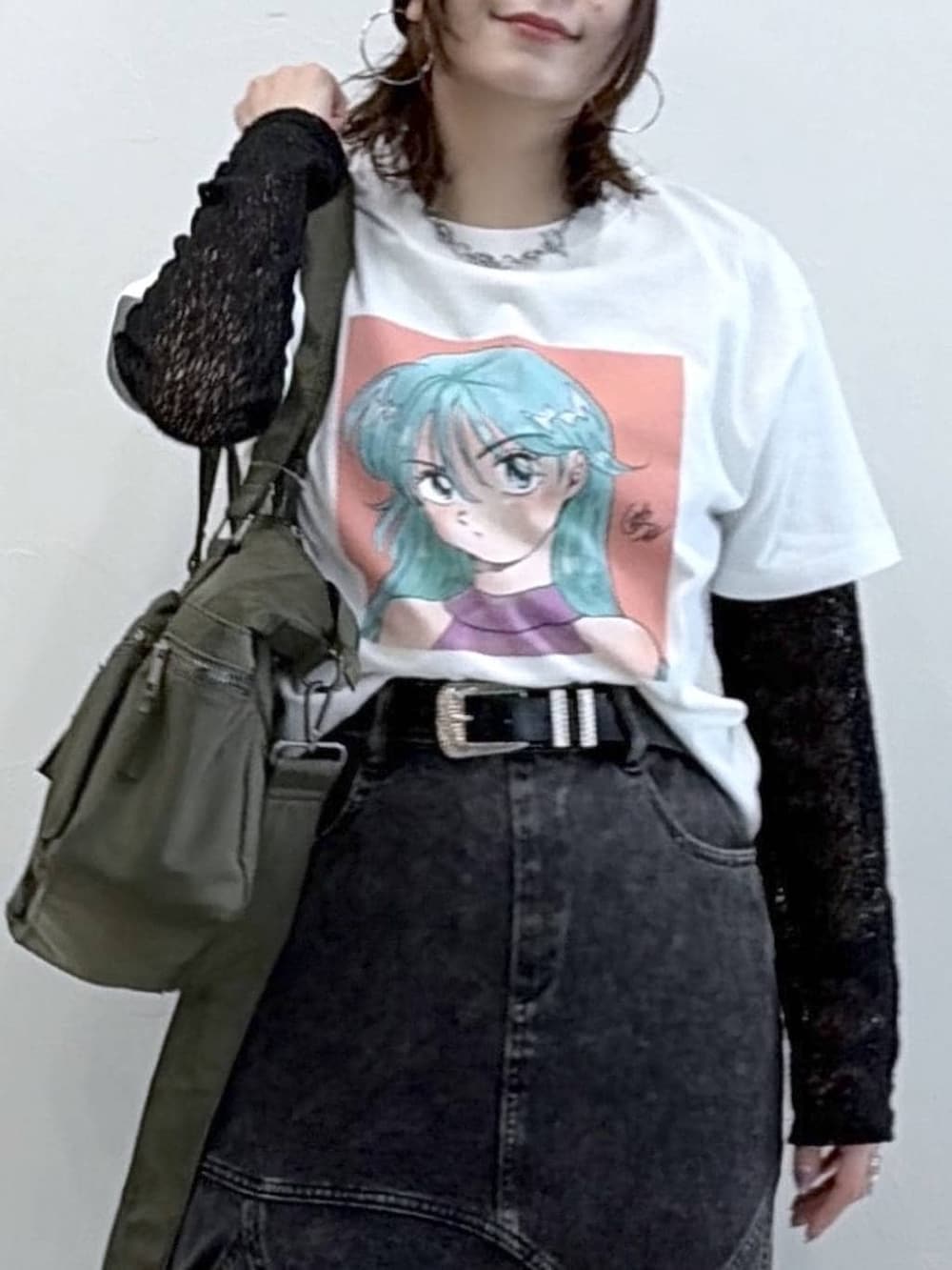 ブラック系のスニーカー、グリーン系のボストンバッグ、ブラック系のデニムスカートを着用したレディースの春コーディネートの2枚目の写真