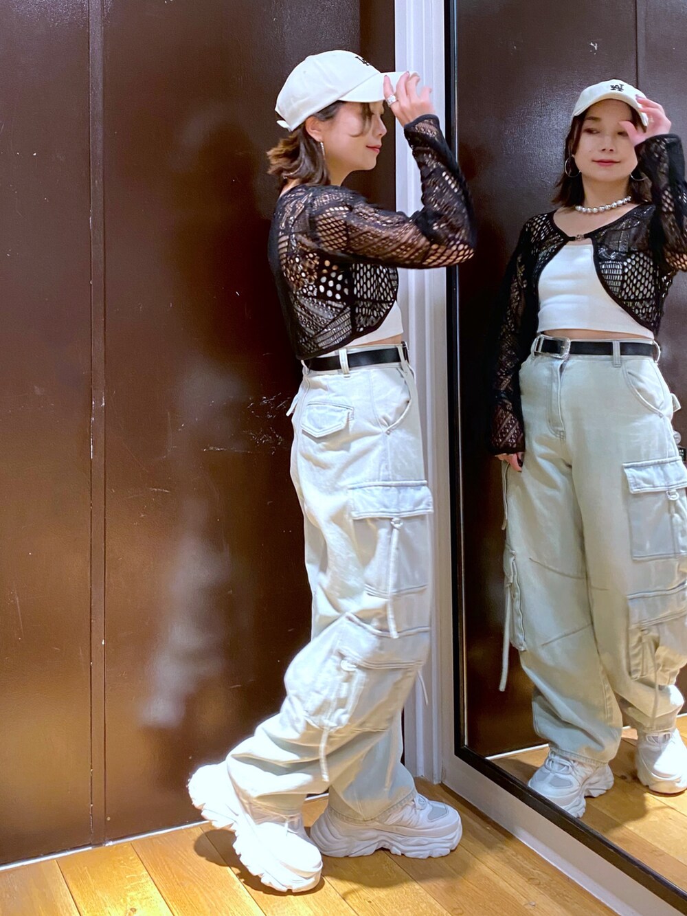 ブルー系のデニムパンツ、ホワイト系のスニーカー、ホワイト系のキャミソールを着用したレディースの夏コーディネートの4枚目の写真