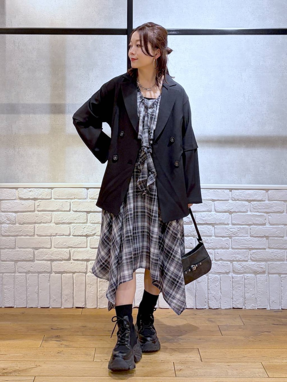 ブラック系のブーツ、ブラック系のハンドバッグ、ブラック系のテーラードジャケットを着用したレディースの春コーディネートの6枚目の写真