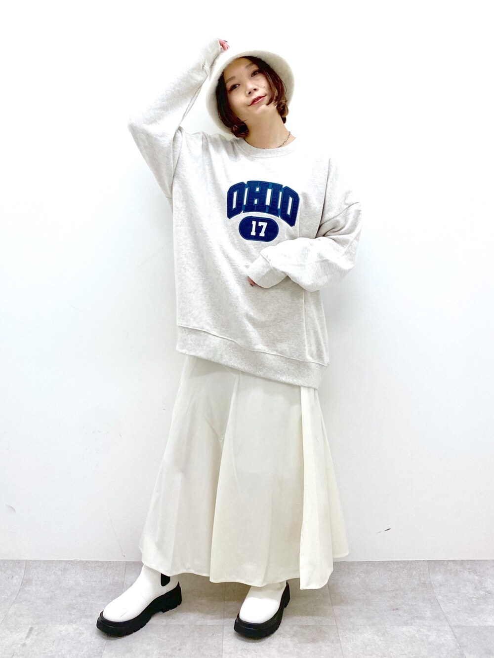 ベージュ系のトップス、ホワイト系のスカート、ホワイト系のシューズを着用したレディースの秋コーディネートの5枚目の写真