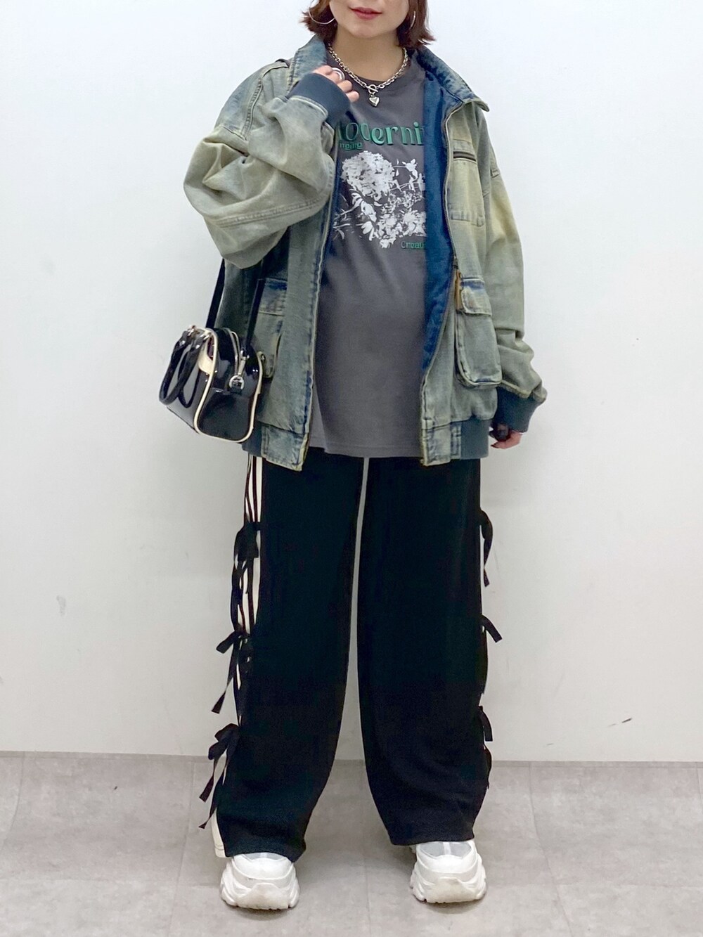 ブラック系のその他パンツ、ホワイト系のスニーカー、ブラック系のショルダーバッグを着用したレディースの秋コーディネートの3枚目の写真