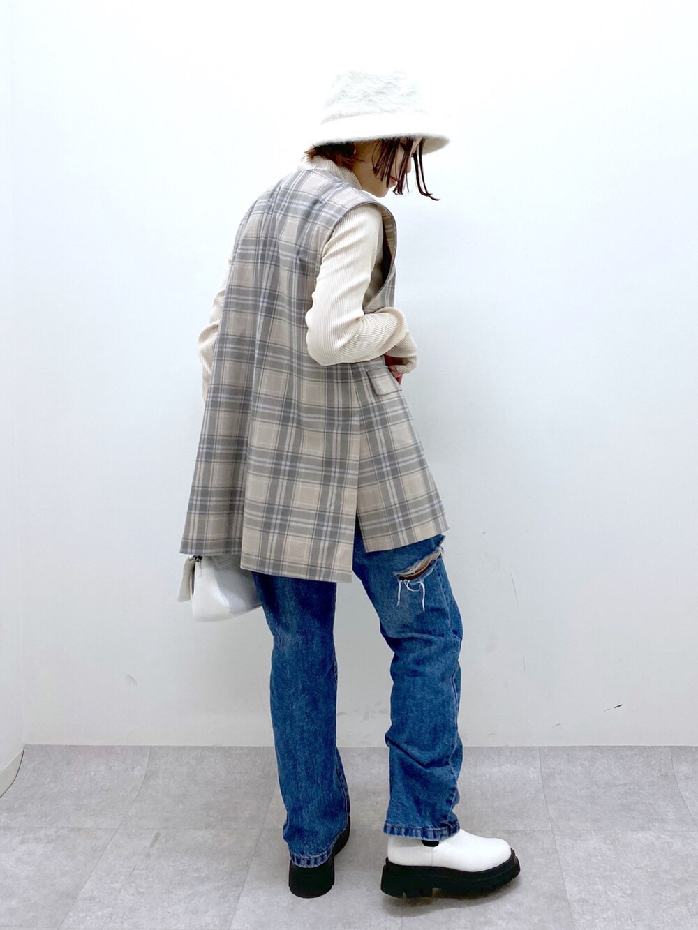 グレー系のジャケット/アウター、ブルー系のデニムパンツ、ホワイト系のバッグを着用したレディースの秋コーディネートの3枚目の写真