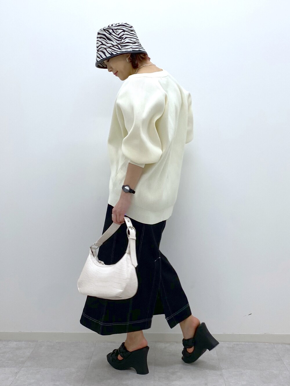 ホワイト系のカーディガン/ボレロ、グリーン系のタンクトップ、ホワイト系のショルダーバッグを着用したレディースの春コーディネートの4枚目の写真