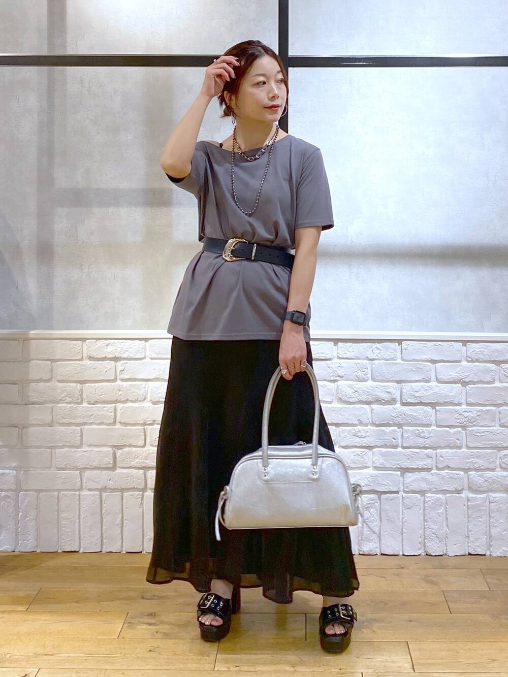 ブラック系のブーツ、シルバー系のショルダーバッグ、グレー系のTシャツ/カットソーを着用したレディースの夏コーディネートの9枚目の写真