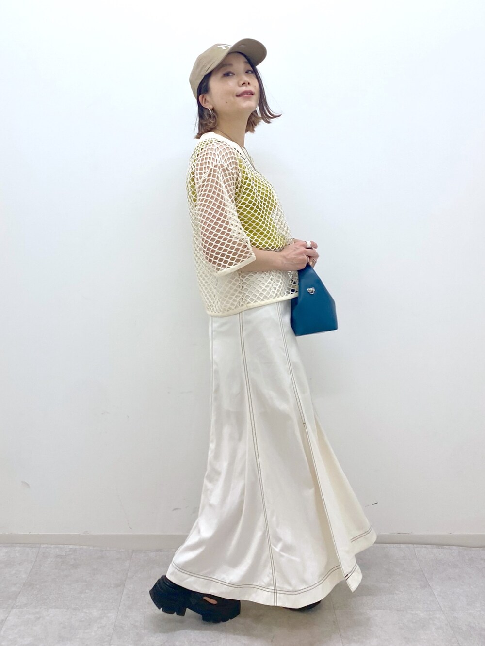 ホワイト系のスカート、ブラック系のサンダル、ブルー系のショルダーバッグを着用したレディースの夏コーディネートの2枚目の写真