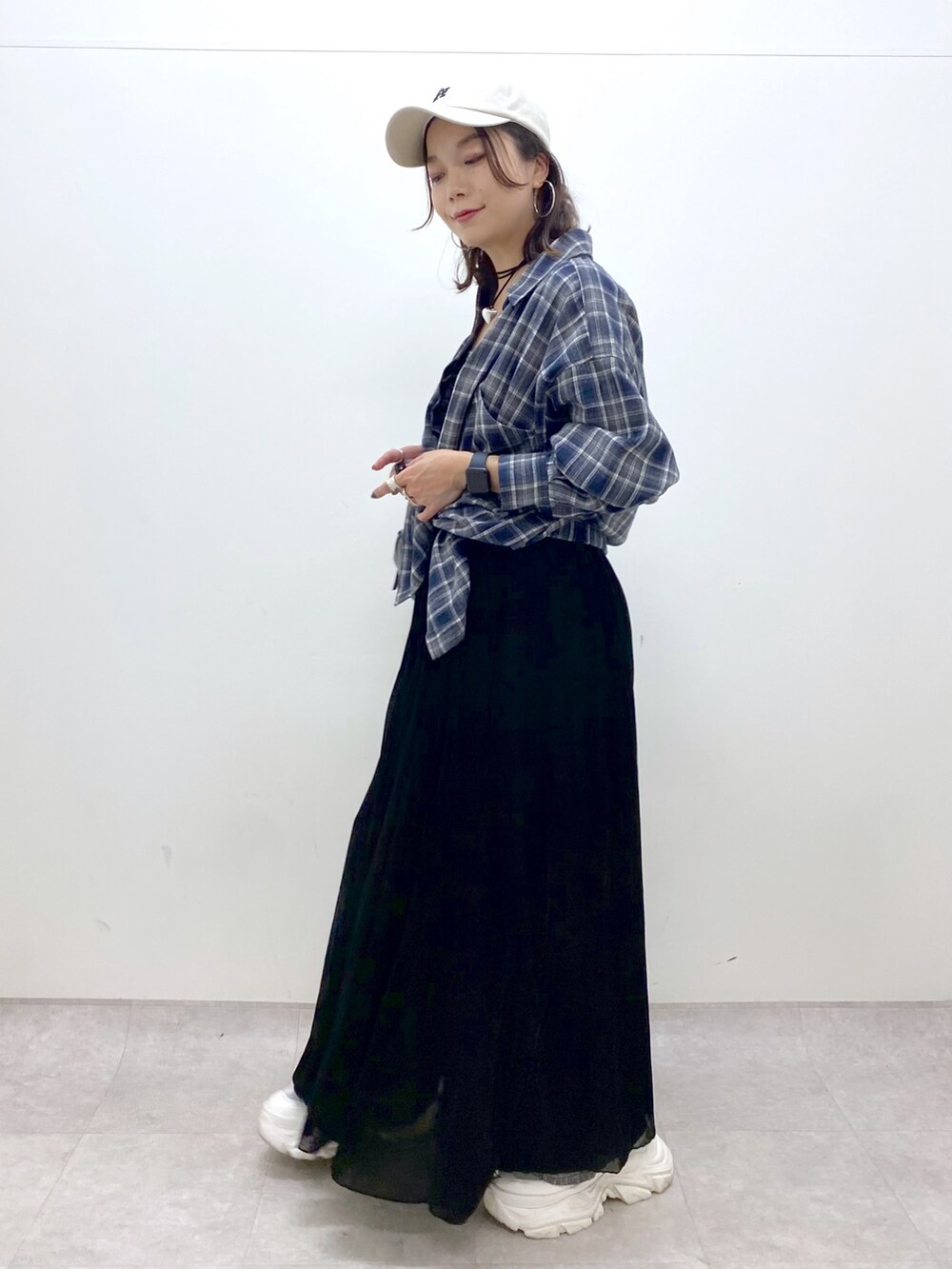 ブラック系のワンピース、ホワイト系のスニーカー、ブラック系のデニムパンツを着用したレディースの夏コーディネートの4枚目の写真