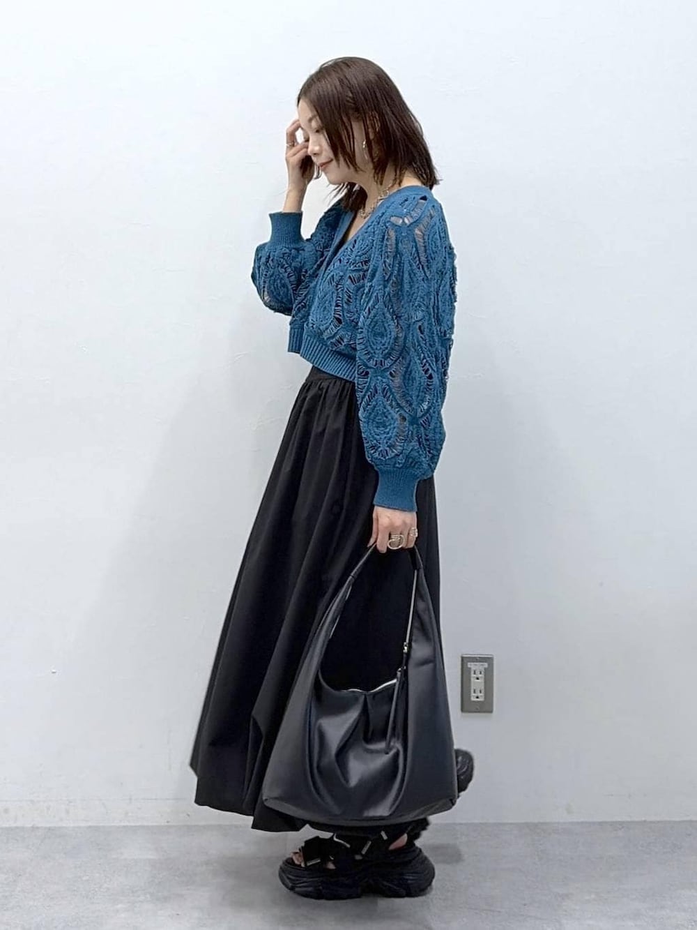 ブルー系のカーディガン/ボレロ、ブラック系のスカートを着用したレディースの春コーディネートの5枚目の写真