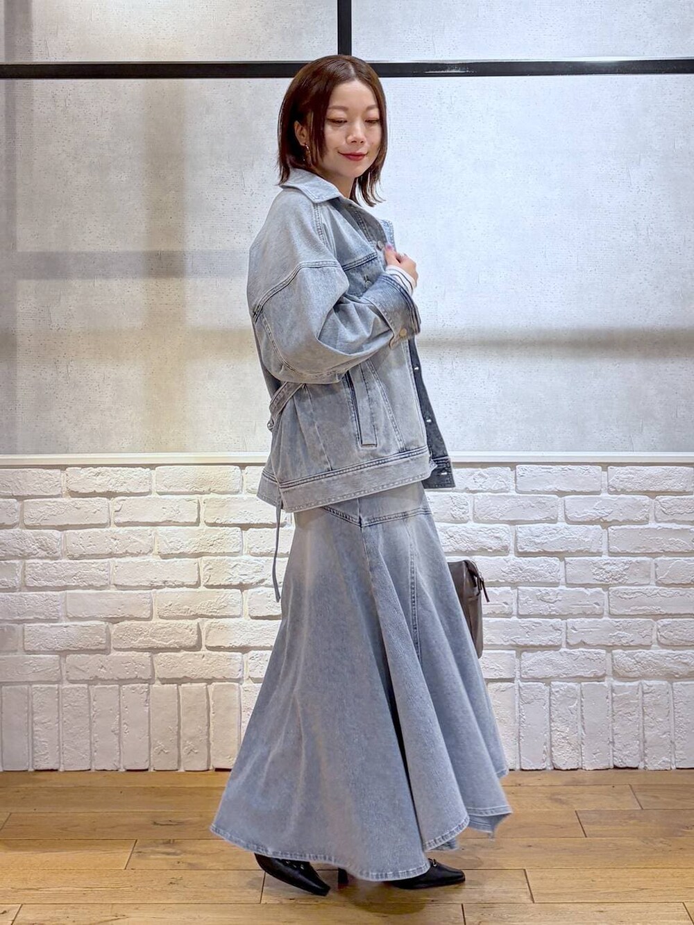 ブルー系のブルゾン、グレー系のショルダーバッグ、ホワイト系のニット/セーターを着用したレディースの春コーディネートの7枚目の写真