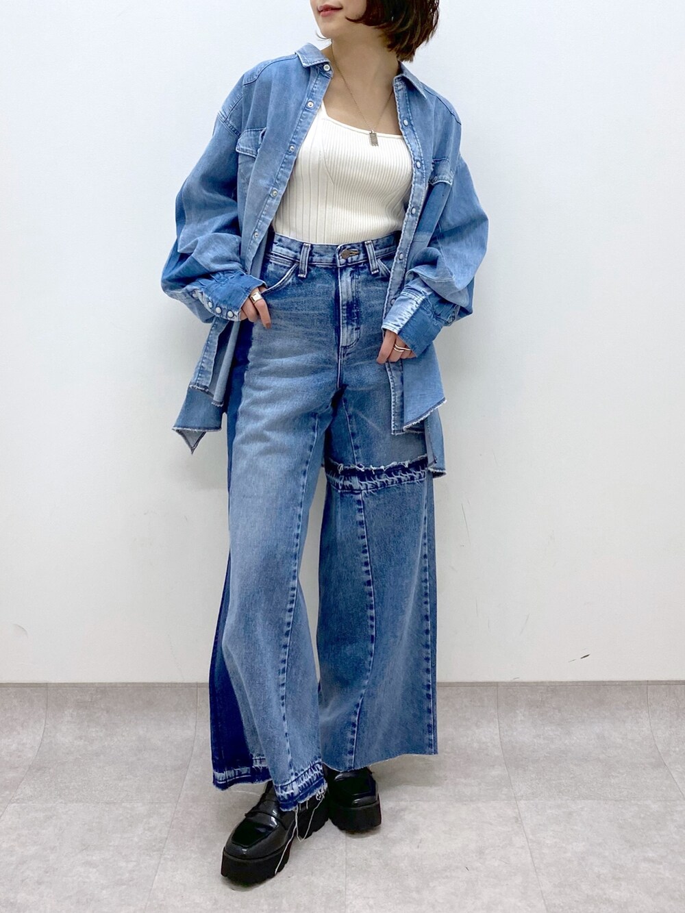 ブルー系のデニムパンツ、ブラック系のローファー、ブルー系のシャツ/ブラウスを着用したレディースの春コーディネートの5枚目の写真