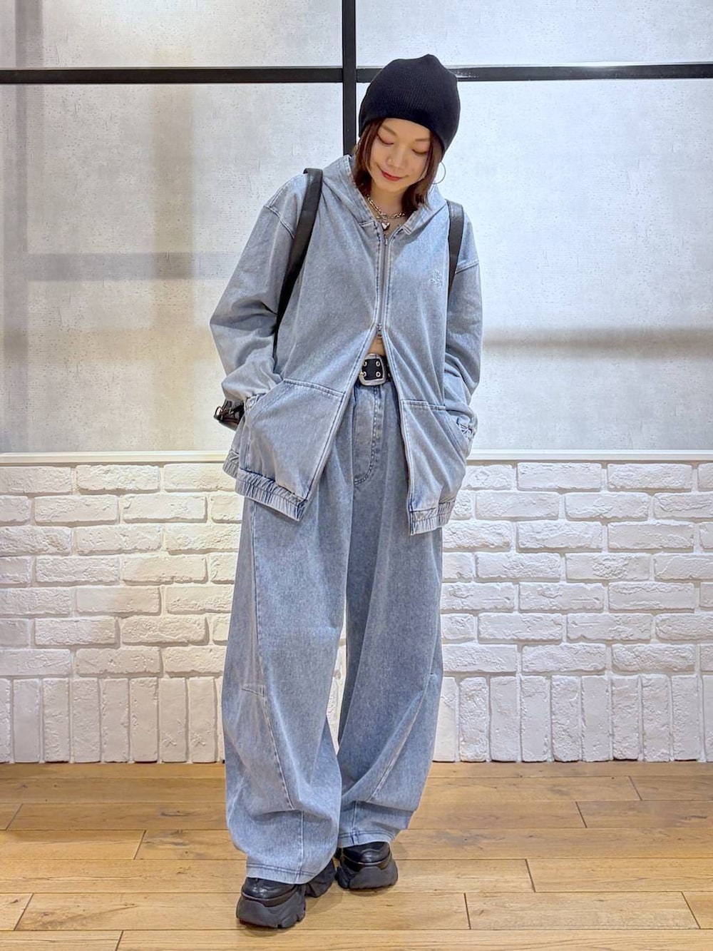 ブラック系のスニーカー、ブラック系のショルダーバッグ、ブルー系のパーカーを着用したレディースの春コーディネートの4枚目の写真