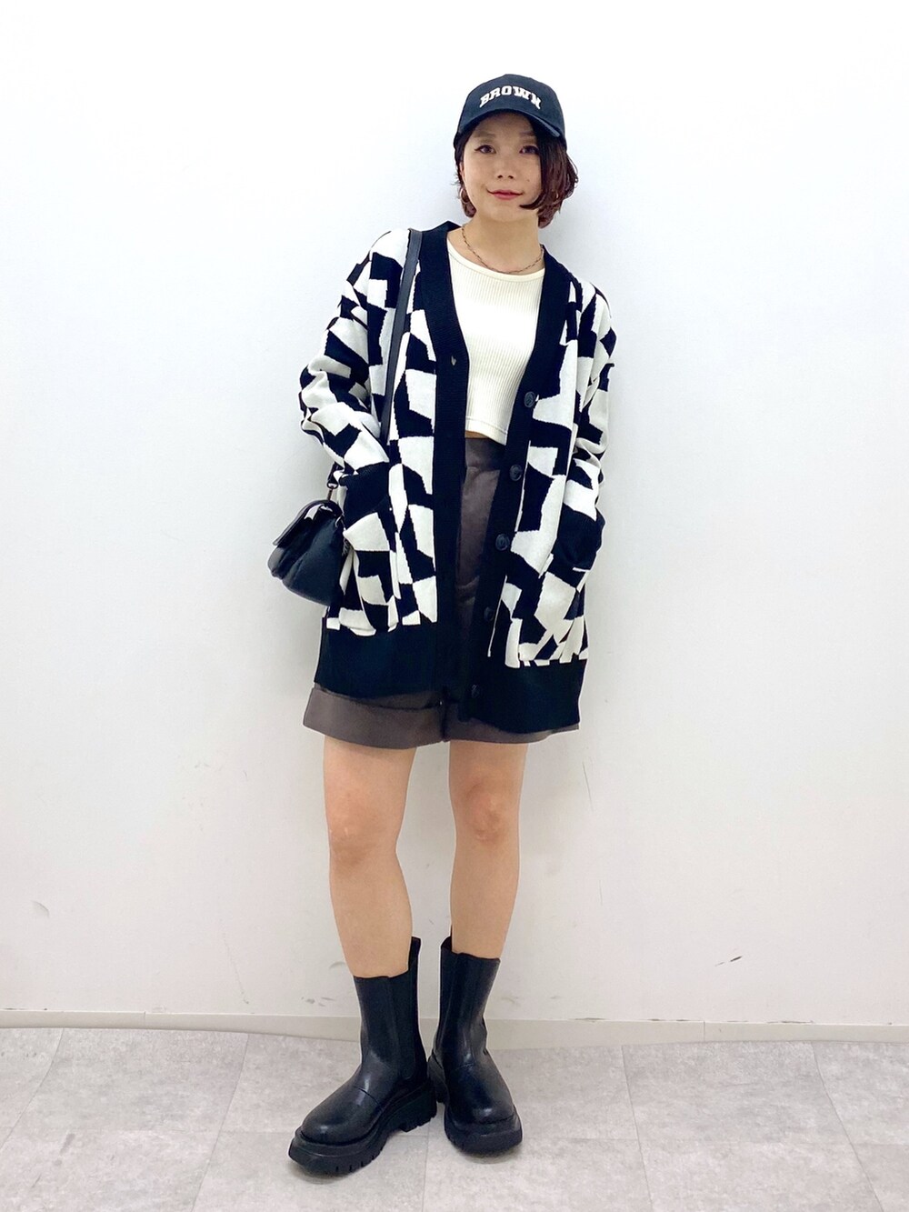 ブラック系のトップス、ブラウン系のパンツ、ホワイト系のTシャツ/カットソーを着用したレディースの秋コーディネートの5枚目の写真