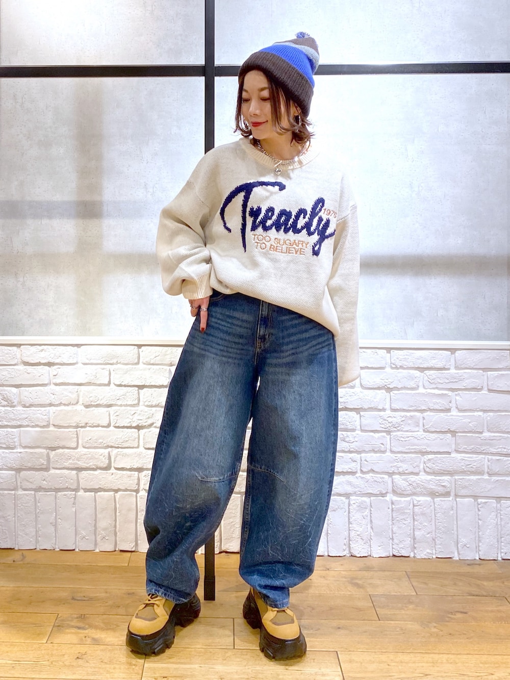 ホワイト系のニット/セーター、ブルー系のデニムパンツ、ブラウン系のブーツを着用したレディースの冬コーディネートの9枚目の写真