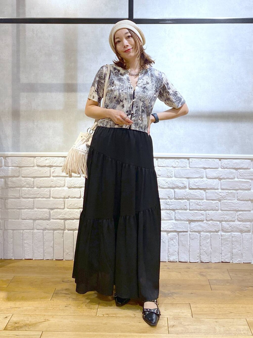 ブラック系のパンプス、ブラック系のスカート、ホワイト系のショルダーバッグを着用したレディースの夏コーディネートの9枚目の写真