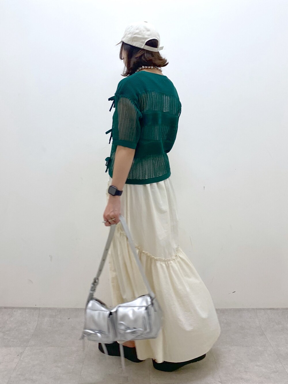 ホワイト系のスカート、グレー系のタンクトップ、シルバー系のショルダーバッグを着用したレディースの夏コーディネートの7枚目の写真