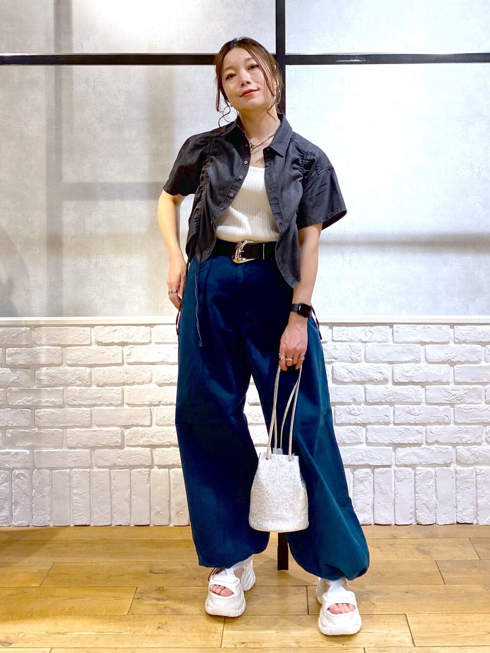 ホワイト系のタンクトップ、ブルー系のチノパンツ、ホワイト系のサンダルを着用したレディースの春コーディネートの9枚目の写真