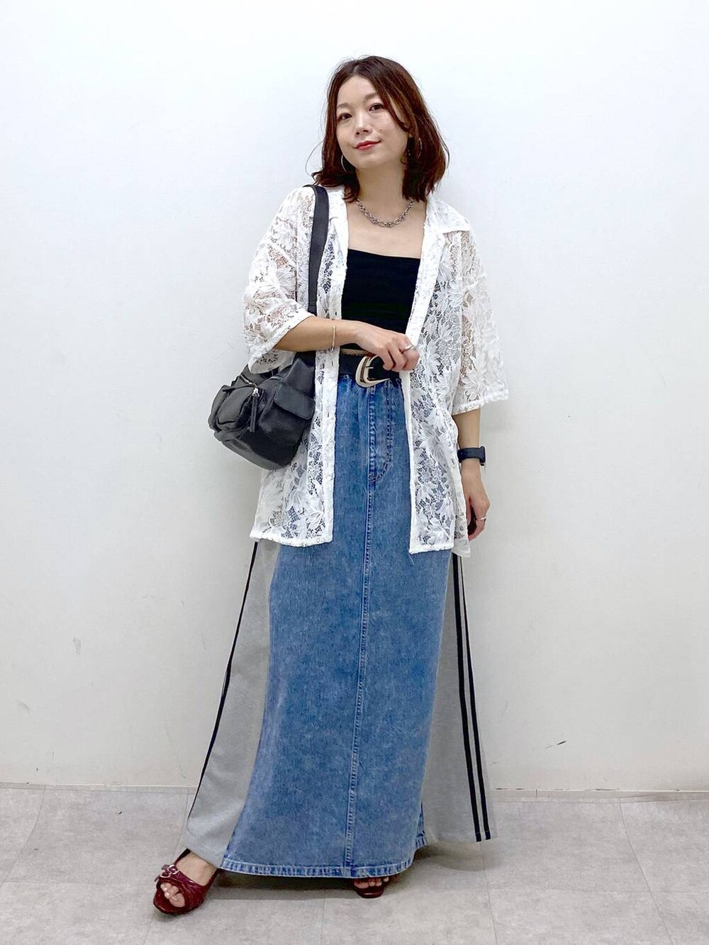 ブラック系のショルダーバッグ、レッド系のサンダル、ブルー系のスカートを着用したレディースの夏コーディネートの9枚目の写真