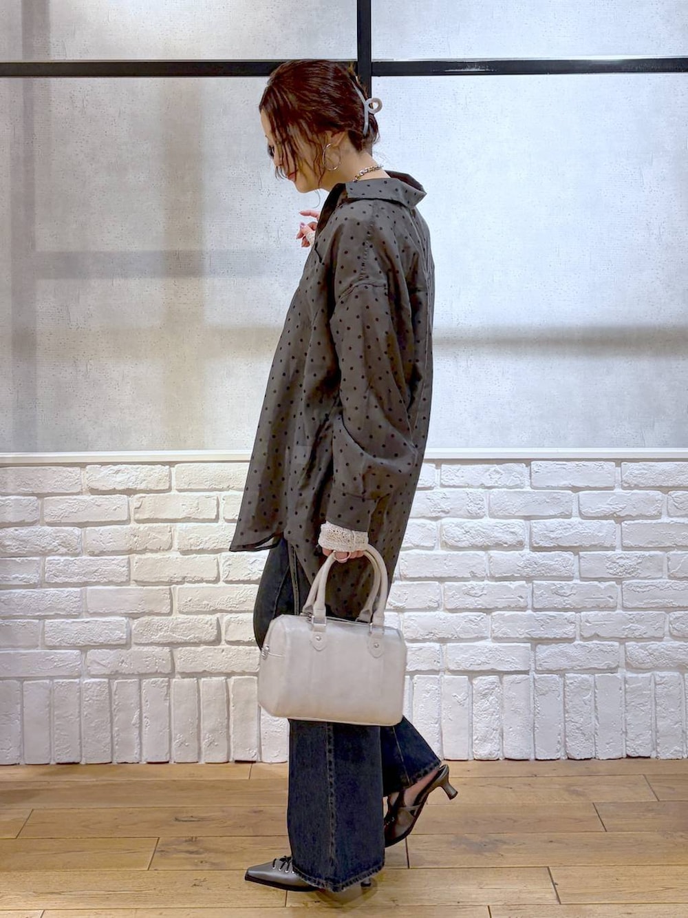 ブルー系のデニムパンツ、ホワイト系のボストンバッグ、ブラウン系のサンダルを着用したレディースの春コーディネートの8枚目の写真