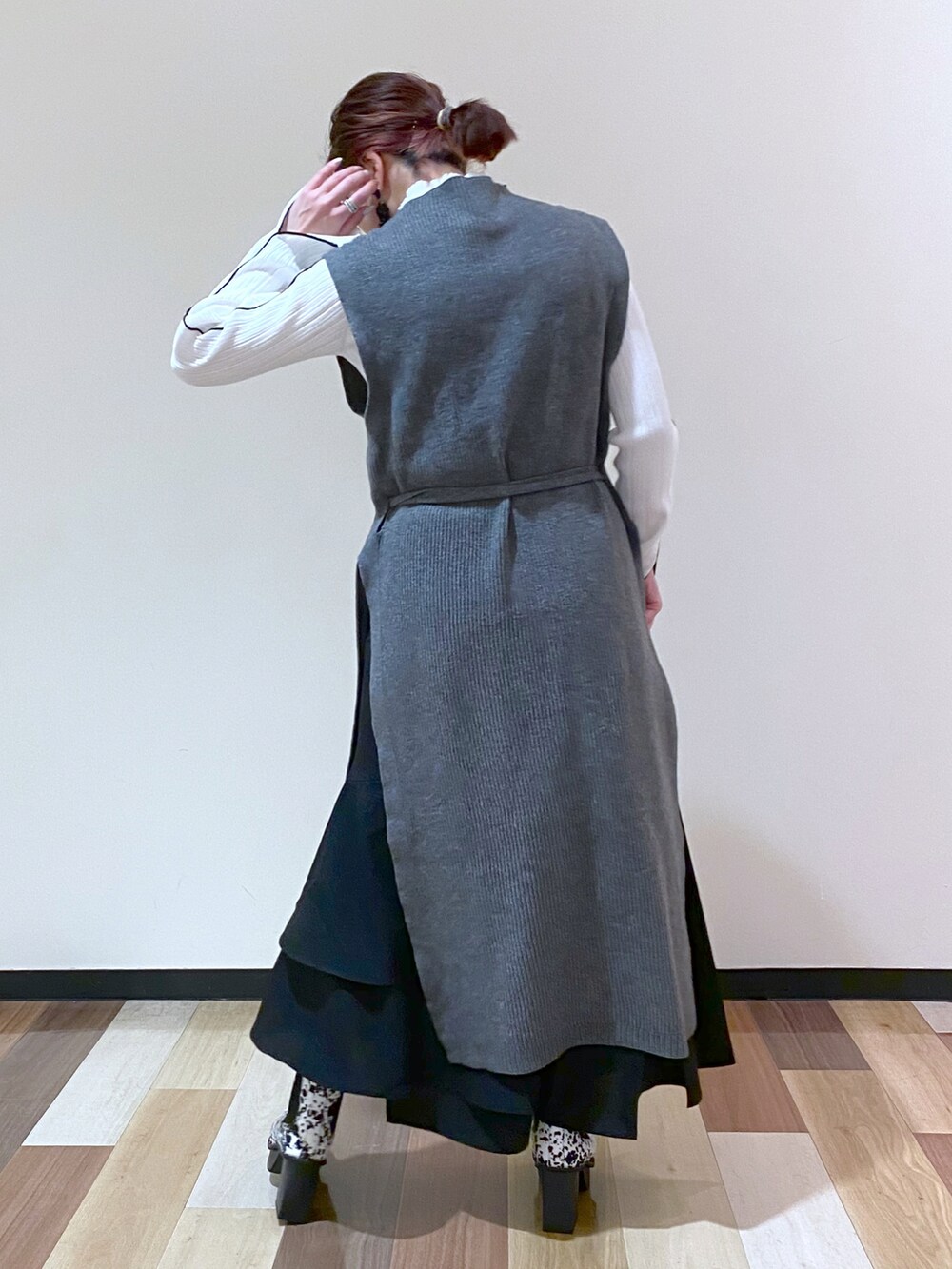 ホワイト系のブーツ、ブラック系のスカート、ホワイト系のニット/セーターを着用したレディースの冬コーディネートの4枚目の写真