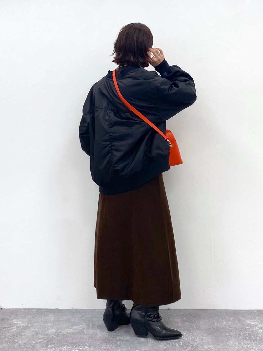 ブラウン系のワンピース、オレンジ系のショルダーバッグ、シルバー系のネックレスを着用したレディースの夏コーディネートの4枚目の写真