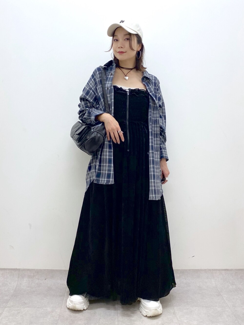 ブラック系のワンピース、ホワイト系のスニーカー、ブラック系のデニムパンツを着用したレディースの夏コーディネートの9枚目の写真