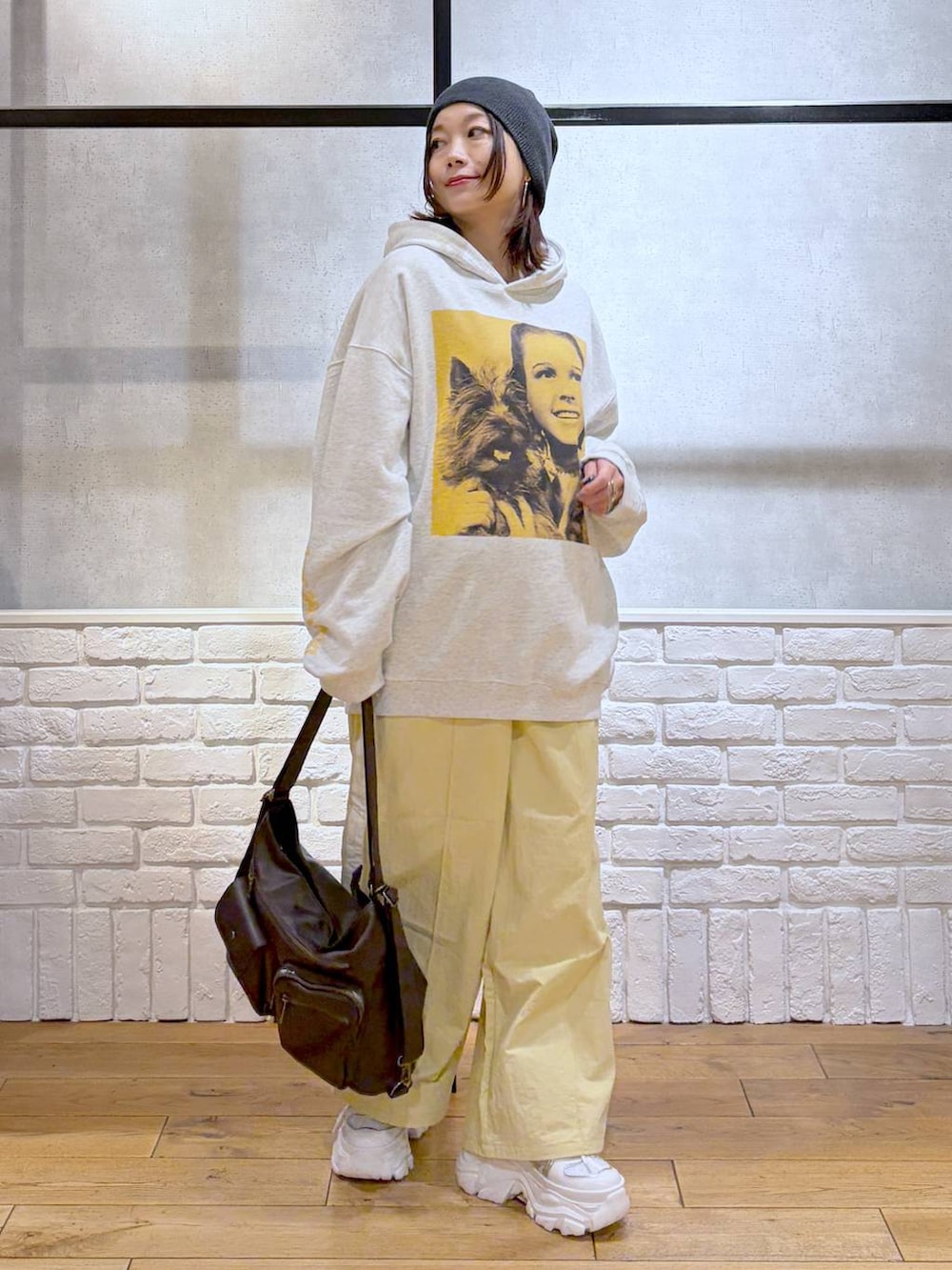ホワイト系のスニーカー、イエロー系のスウェットパンツ、ブラウン系のショルダーバッグを着用したレディースの春コーディネートの8枚目の写真