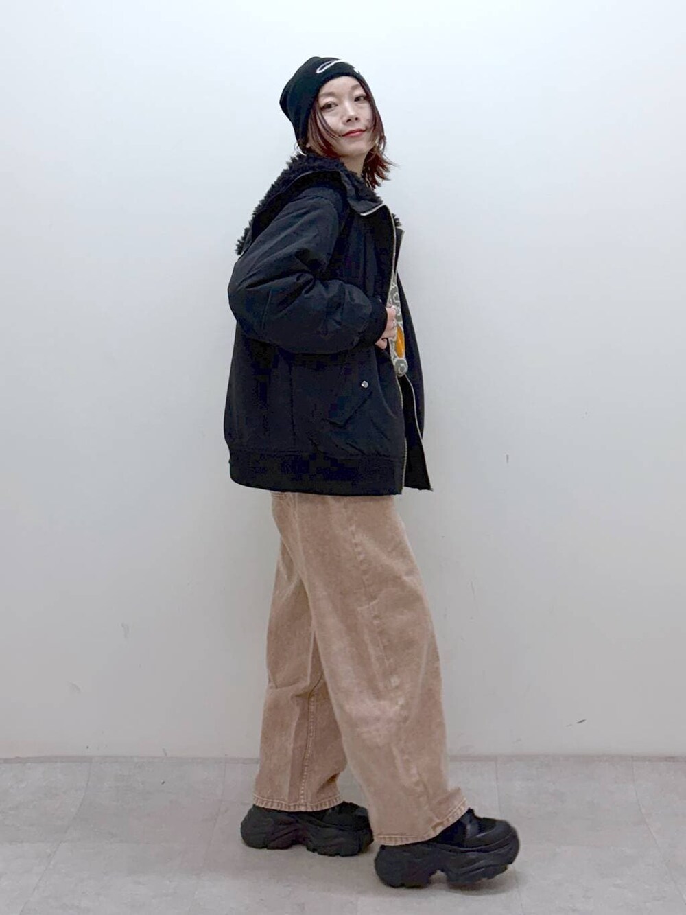 ブラック系のブーツ、ブラック系のボストンバッグ、ブラック系のブルゾンを着用したレディースの冬コーディネートの8枚目の写真