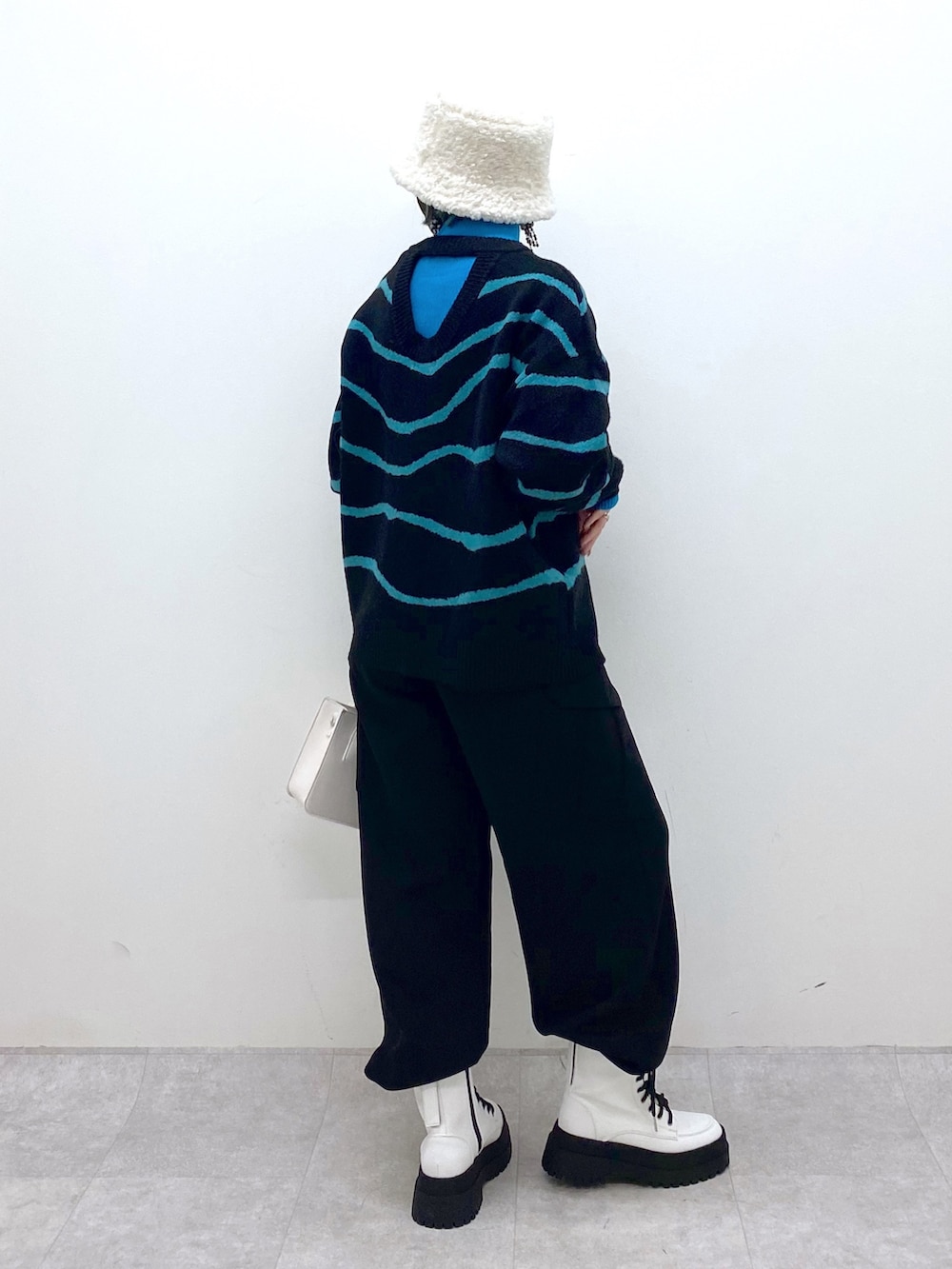 ブラック系のトップス、ブラック系のカーゴパンツ、ホワイト系のバッグを着用したレディースの秋コーディネートの3枚目の写真