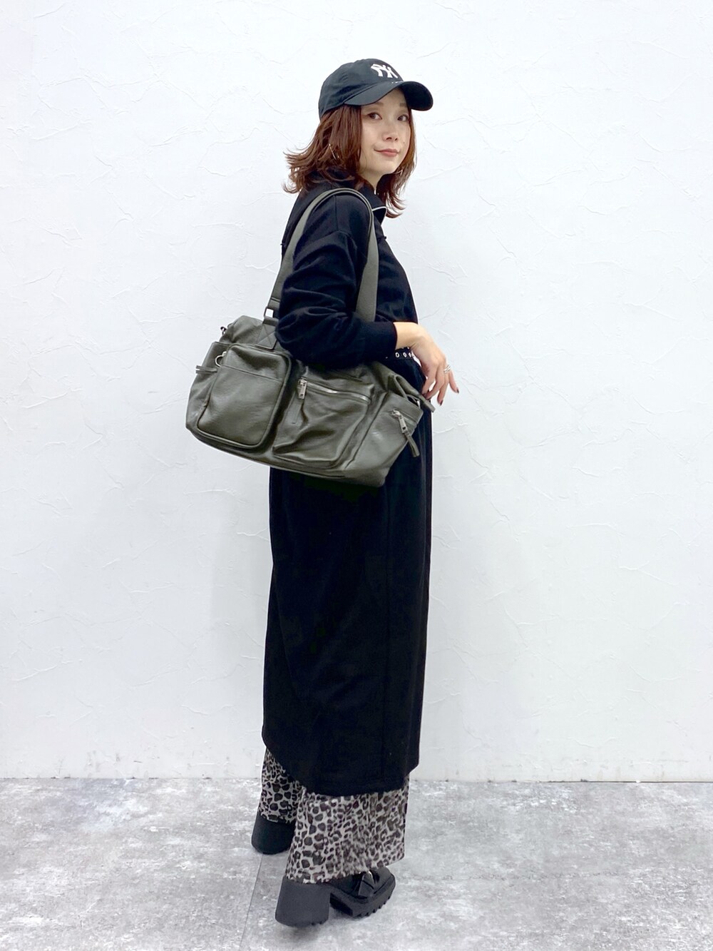 ブラック系のワンピース、その他のその他パンツ、グリーン系のボストンバッグを着用したレディースの秋コーディネートの6枚目の写真