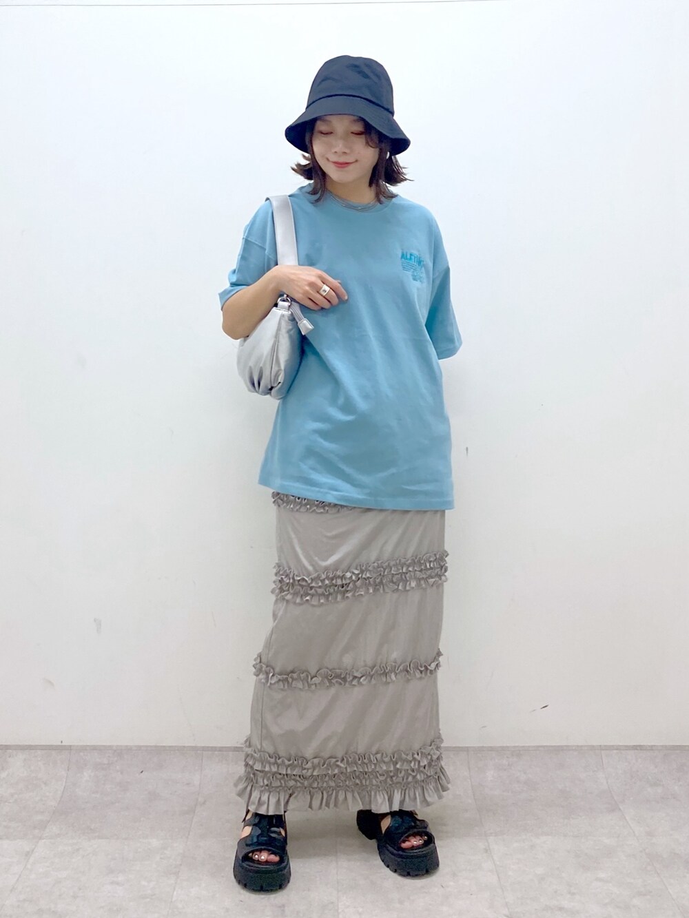 ブルー系のTシャツ/カットソー、シルバー系のショルダーバッグ、グレー系のスカートを着用したレディースの夏コーディネートの9枚目の写真