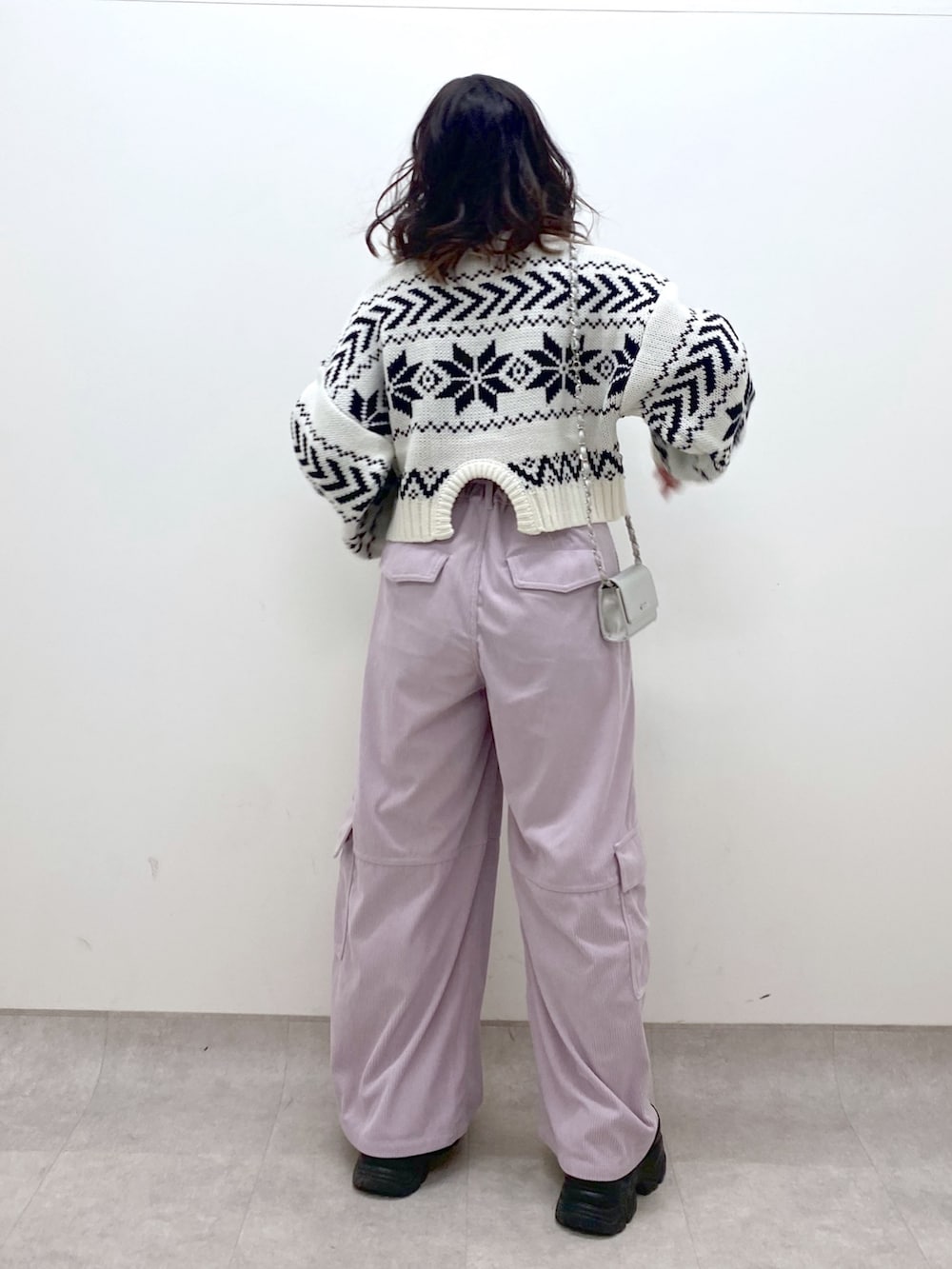 グレー系のチェスターコート、ホワイト系のニット/セーター、ピンク系のカーゴパンツを着用したレディースの冬コーディネートの7枚目の写真