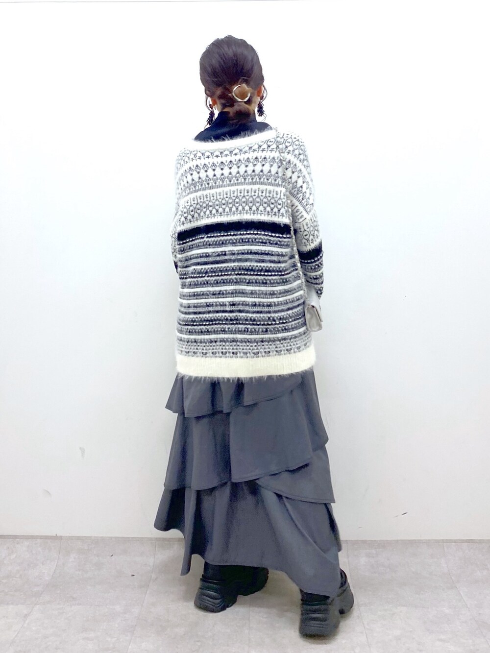 ホワイト系のカーディガン/ボレロ、グレー系のスカート、ブラック系のスニーカーを着用したレディースの冬コーディネートの4枚目の写真