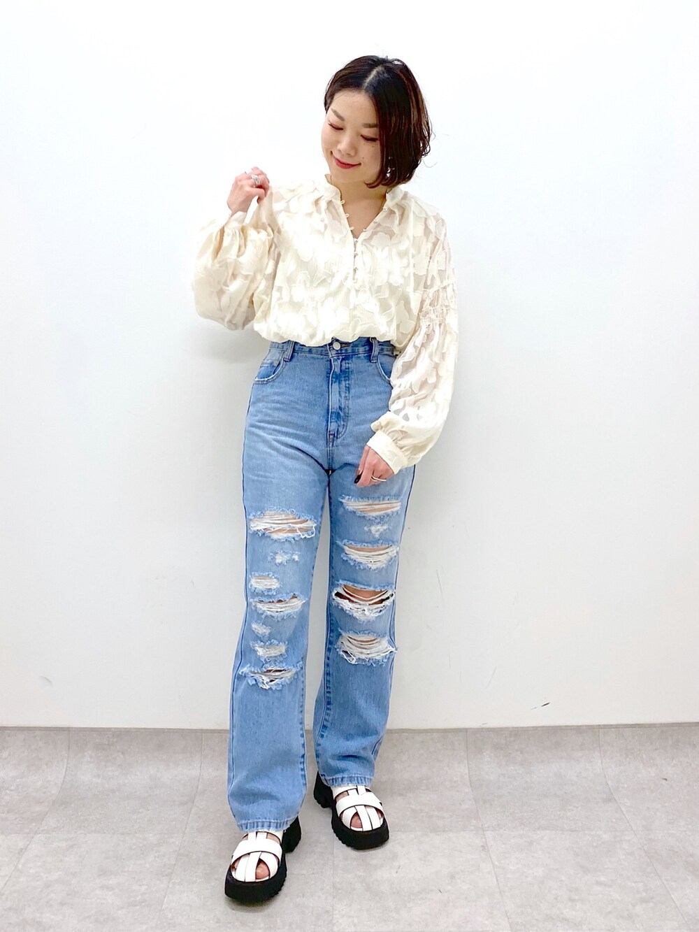 ブルー系のパンツ、ホワイト系のトップス、ホワイト系のサンダルを着用したレディースの春コーディネートの5枚目の写真