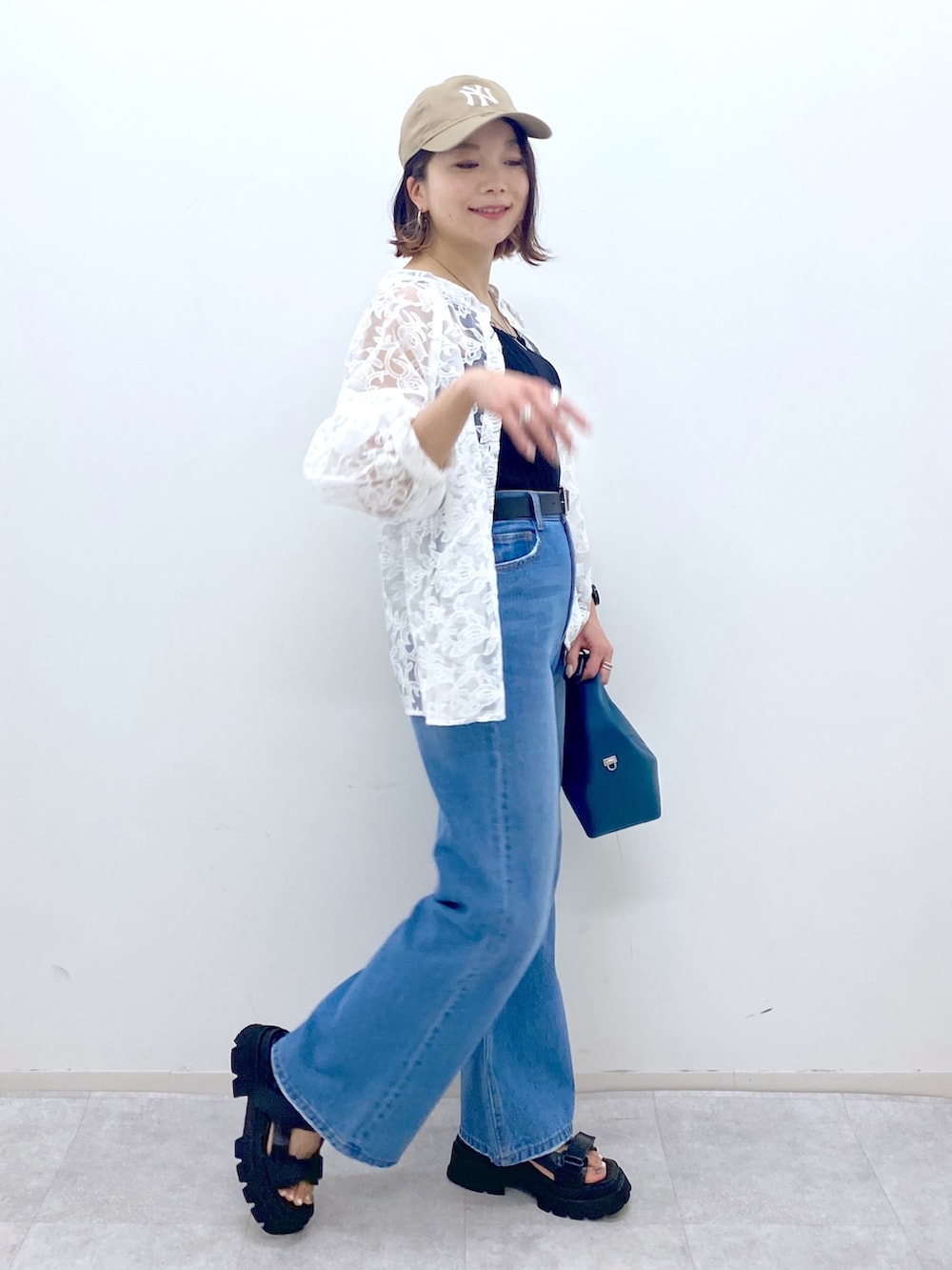 ブルー系のパンツ、ブラック系のサンダル、ブルー系のショルダーバッグを着用したレディースの夏コーディネートの3枚目の写真