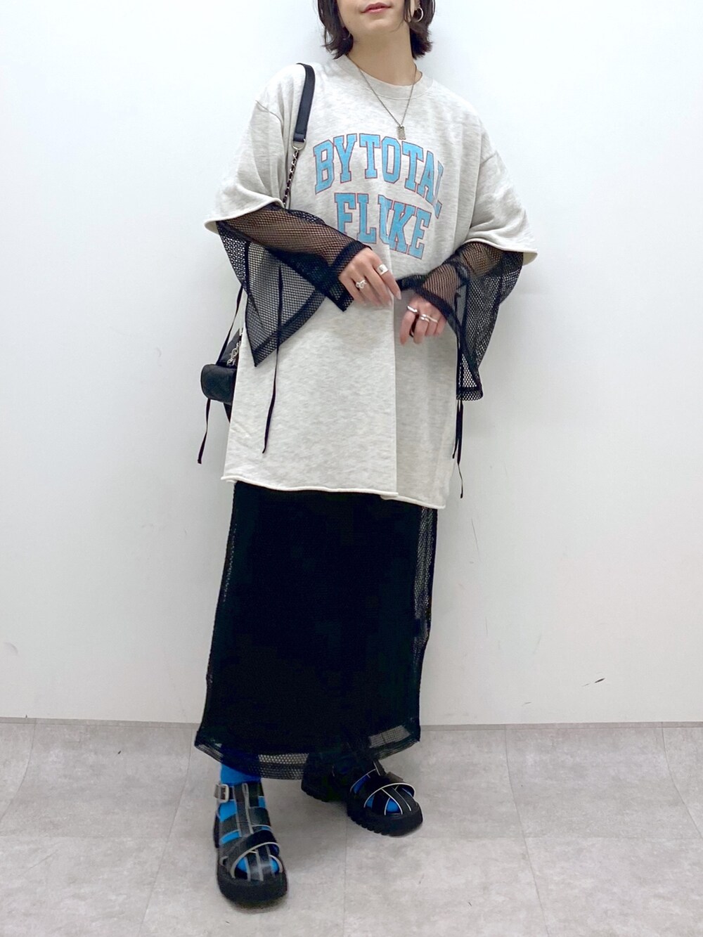 ベージュ系のトップス、ブラック系のワンピース/ドレス、ブラック系のサンダルを着用したレディースの春コーディネートの4枚目の写真