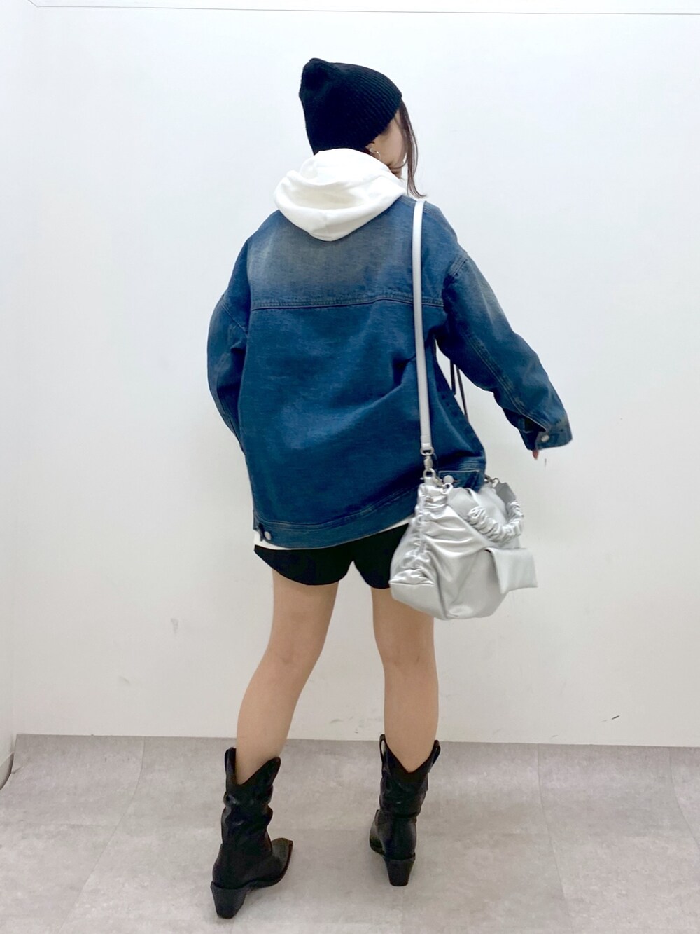 ブルー系のデニムジャケット、シルバー系のショルダーバッグ、ブラック系のその他パンツを着用したレディースの冬コーディネートの6枚目の写真