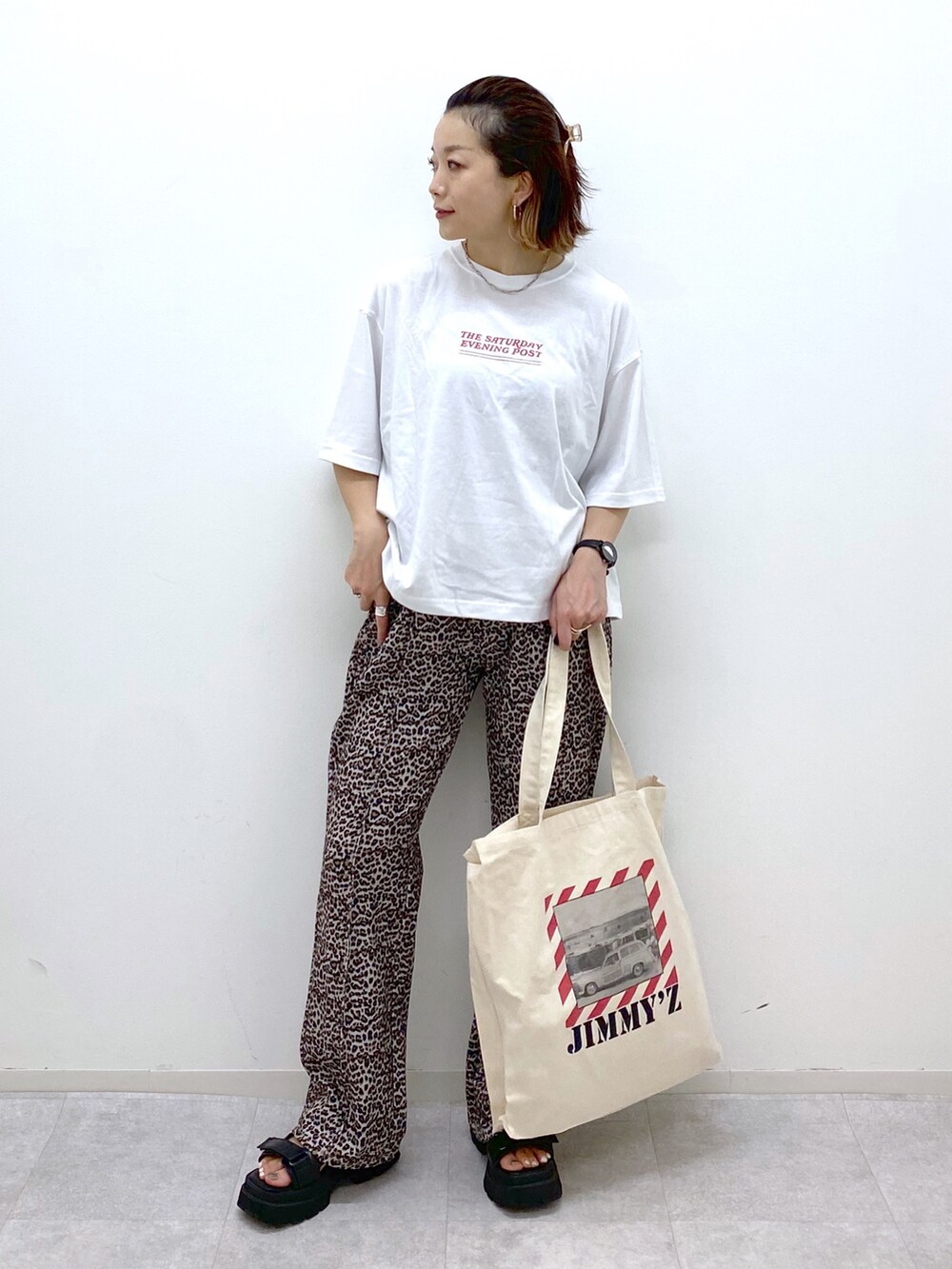 ブラック系のショルダーバッグ、ブラック系のサンダル、ブラック系のTシャツ/カットソーを着用したレディースの夏コーディネートの3枚目の写真