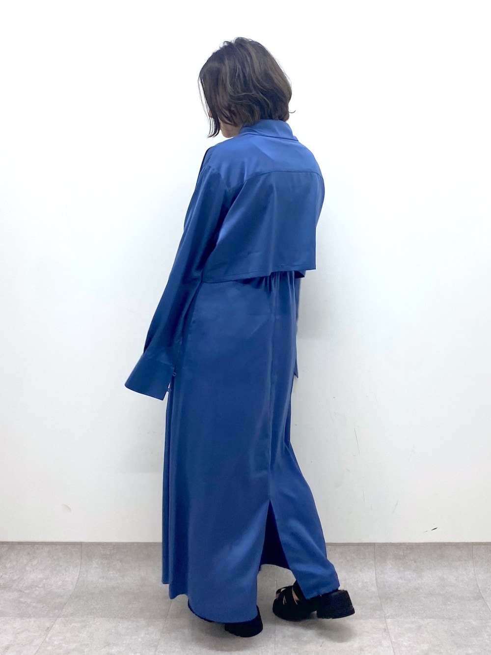 ブルー系のワンピース/ドレス、ブラック系のTシャツ/カットソー、ブラック系のサンダルを着用したレディースの春コーディネートの3枚目の写真