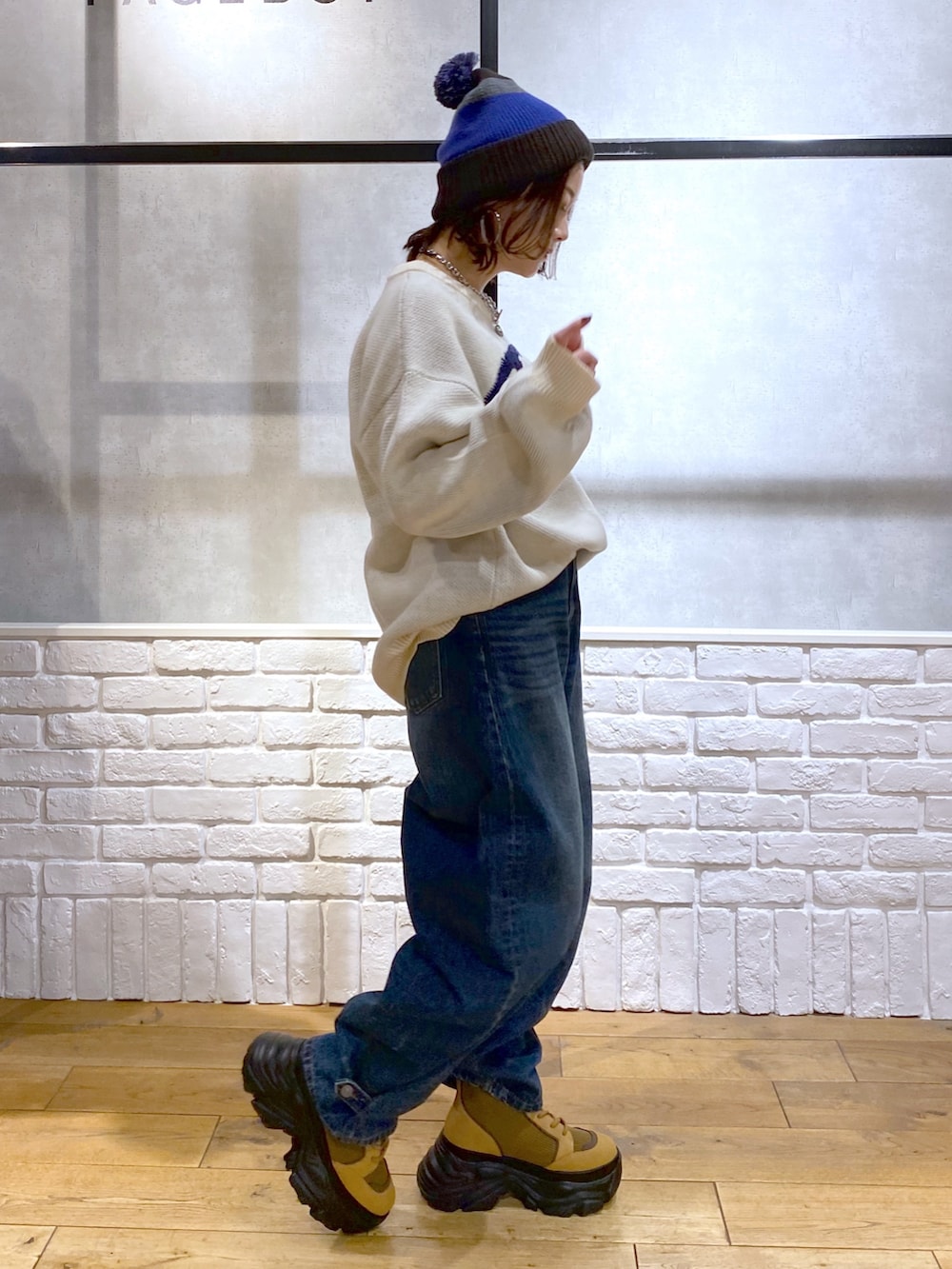 ホワイト系のニット/セーター、ブルー系のデニムパンツ、ブラウン系のブーツを着用したレディースの冬コーディネートの6枚目の写真