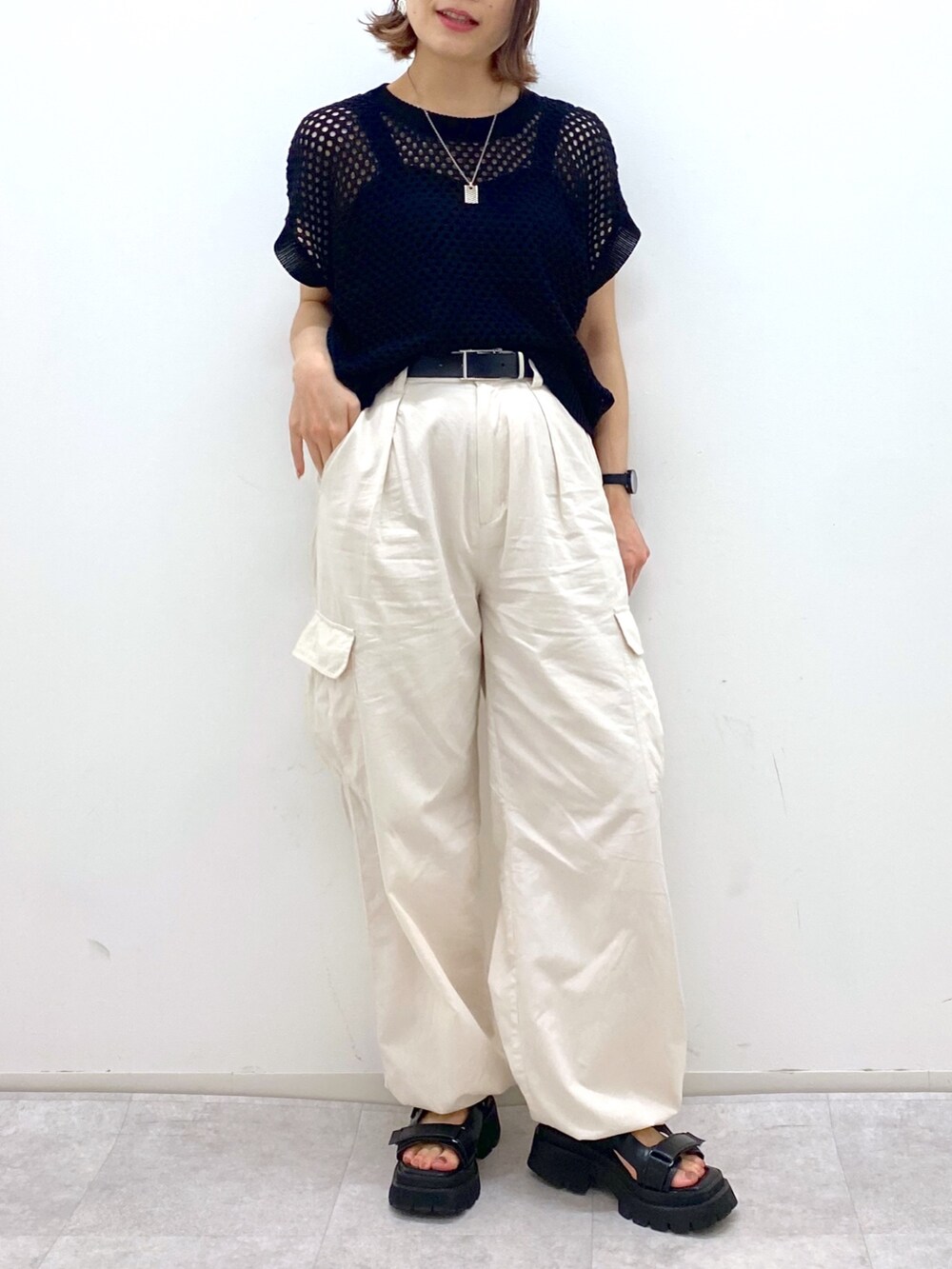 ホワイト系のカーゴパンツ、ブラック系のトップス、ブラック系のサンダルを着用したレディースの夏コーディネートの4枚目の写真