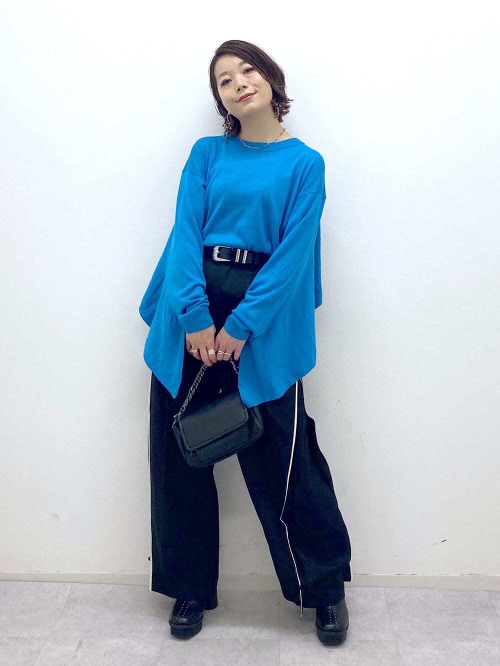 ブラック系のブーツ、ブラック系のパンツ、ブラック系のバッグを着用したレディースの秋コーディネートの5枚目の写真