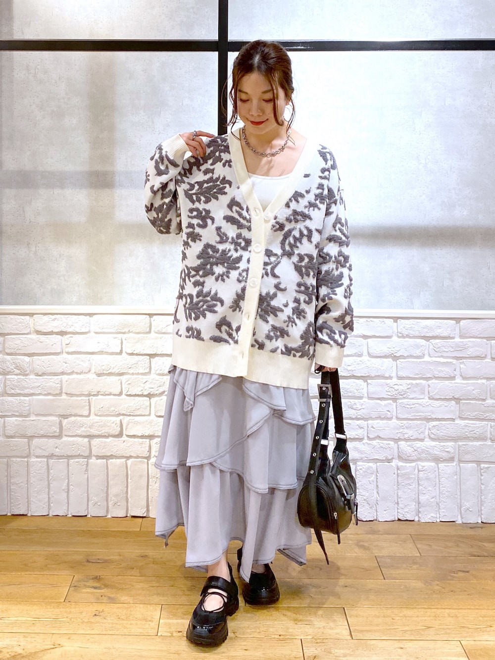 ブラック系のショルダーバッグ、ホワイト系のカーディガン/ボレロ、ホワイト系のキャミソールを着用したレディースの春コーディネートの9枚目の写真