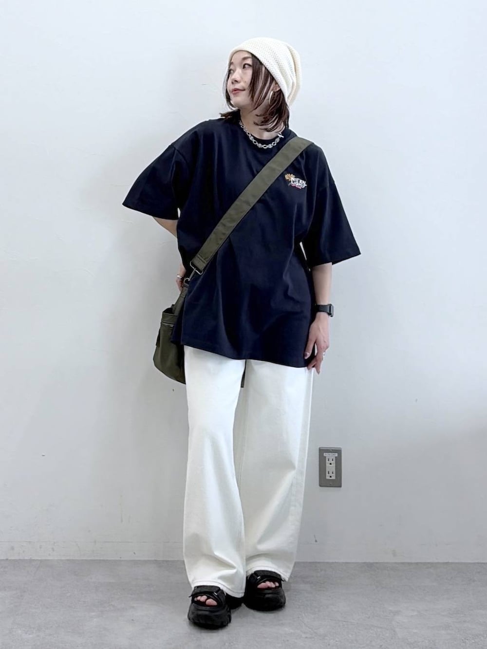 グリーン系のボストンバッグ、ホワイト系のスラックス、ブルー系のTシャツ/カットソーを着用したレディースの春コーディネートの8枚目の写真