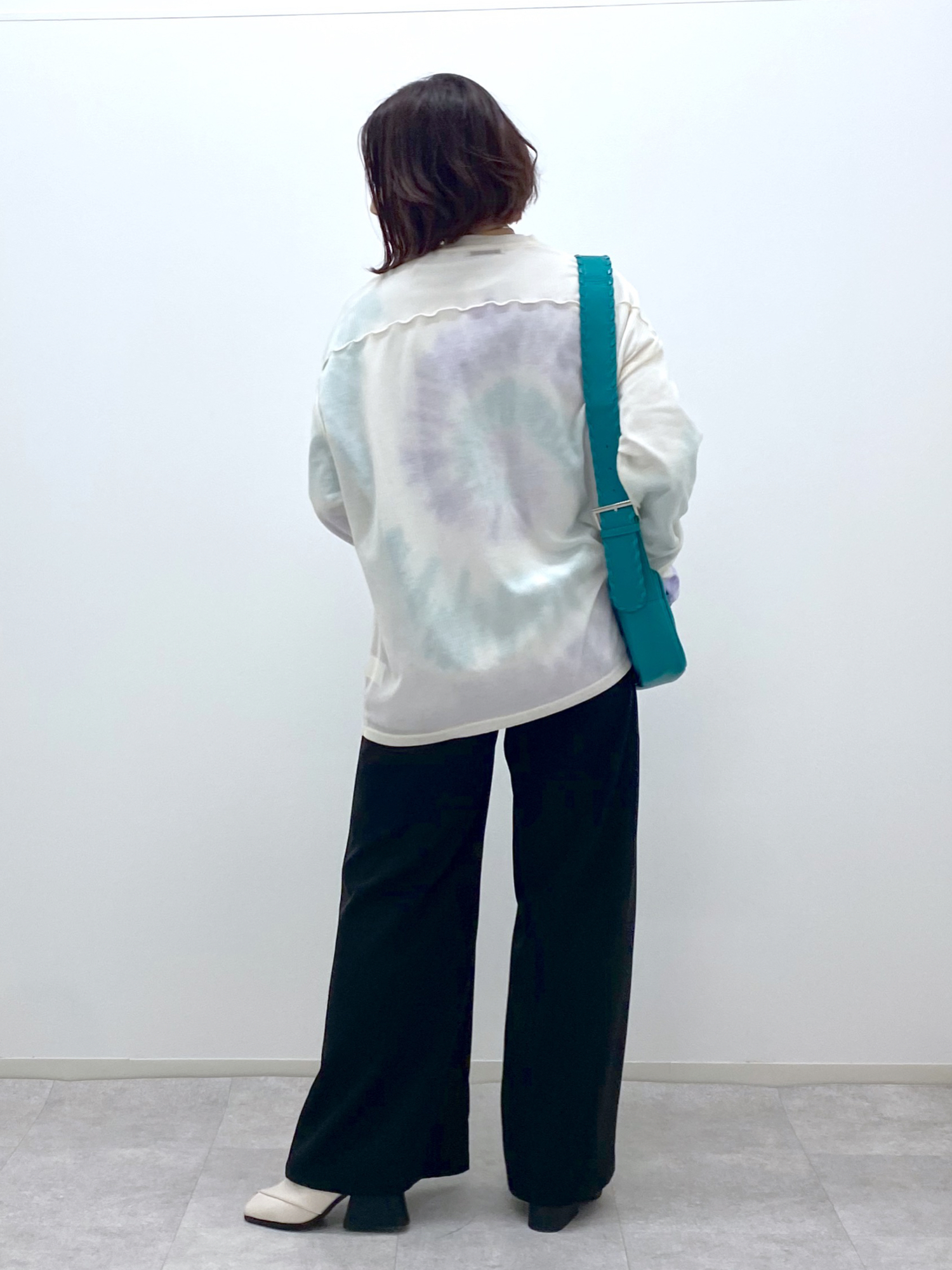 ブラック系のスラックス、ホワイト系のTシャツ/カットソー、ホワイト系のTシャツ/カットソーを着用したレディースの冬コーディネートの4枚目の写真