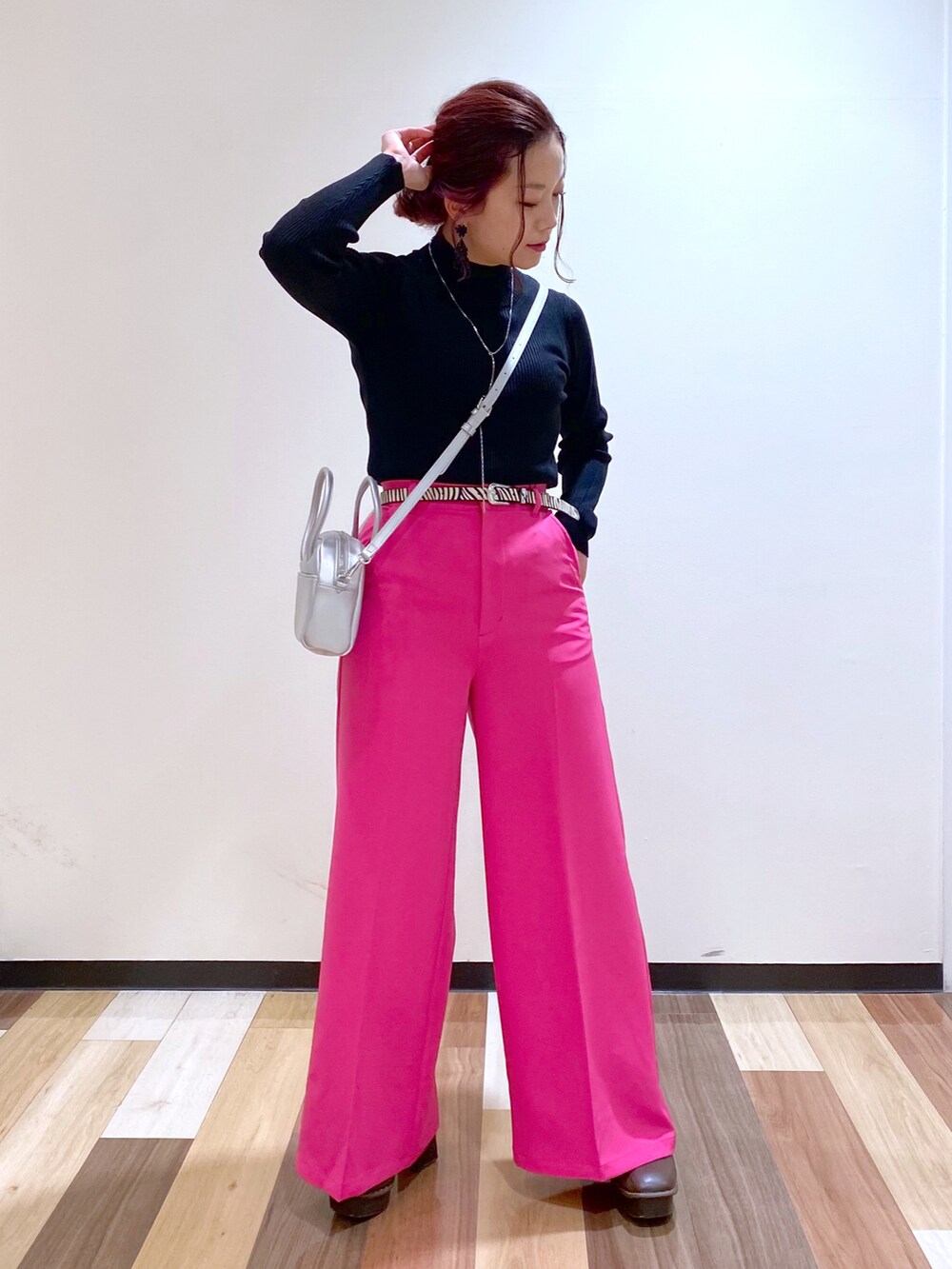 ブラック系のニット/セーター、シルバー系のボストンバッグ、ピンク系のスラックスを着用したレディースの冬コーディネートの4枚目の写真