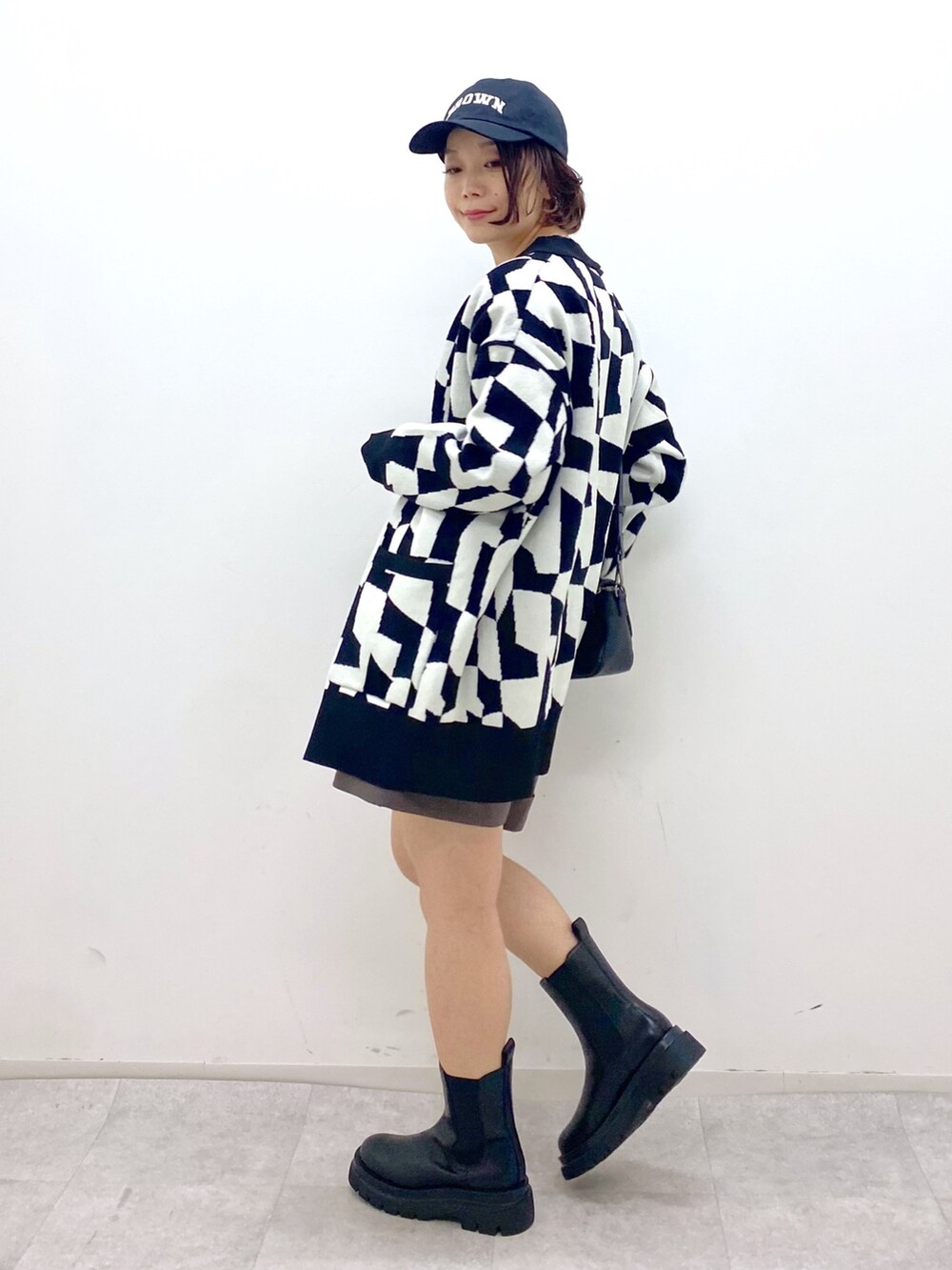 ブラック系のトップス、ブラウン系のパンツ、ホワイト系のTシャツ/カットソーを着用したレディースの秋コーディネートの2枚目の写真