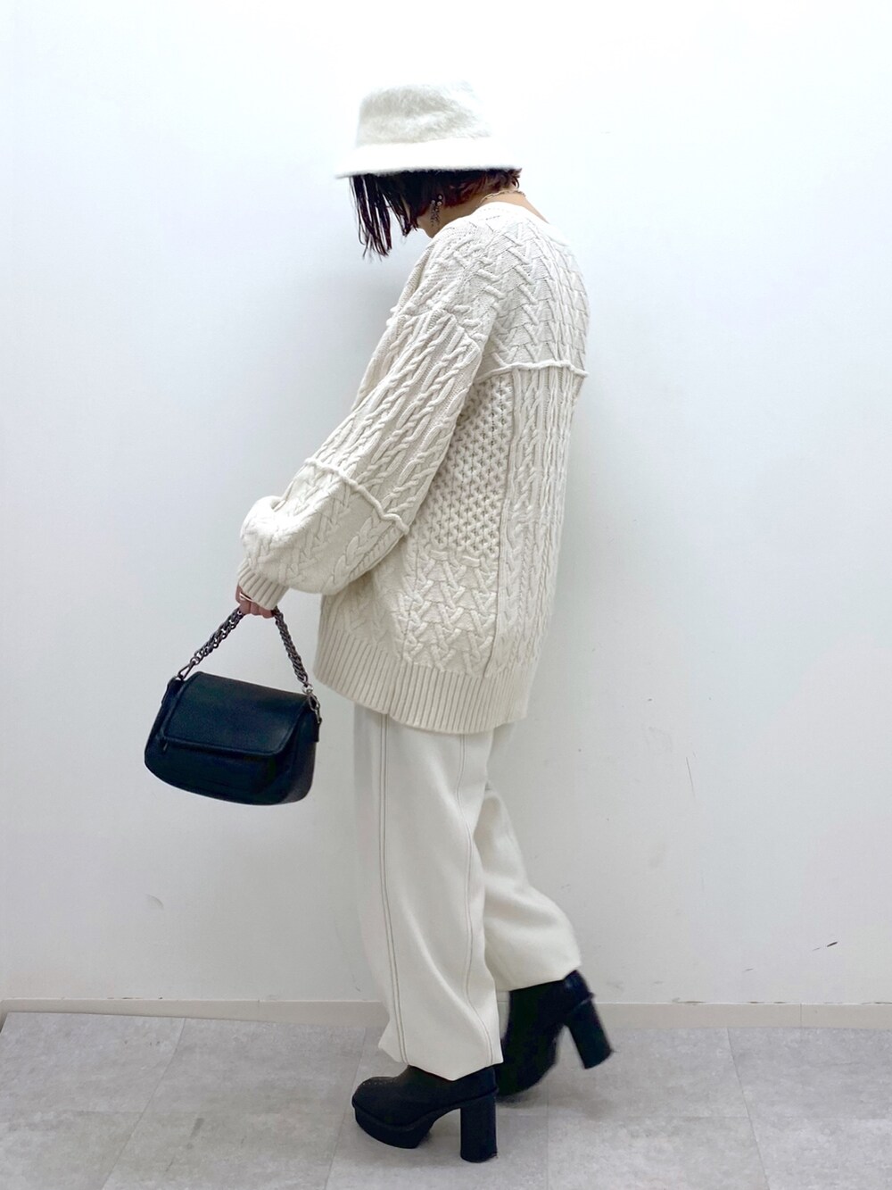 ホワイト系のその他パンツ、ブラック系のバッグ、ブラック系のブーツを着用したレディースの秋コーディネートの2枚目の写真