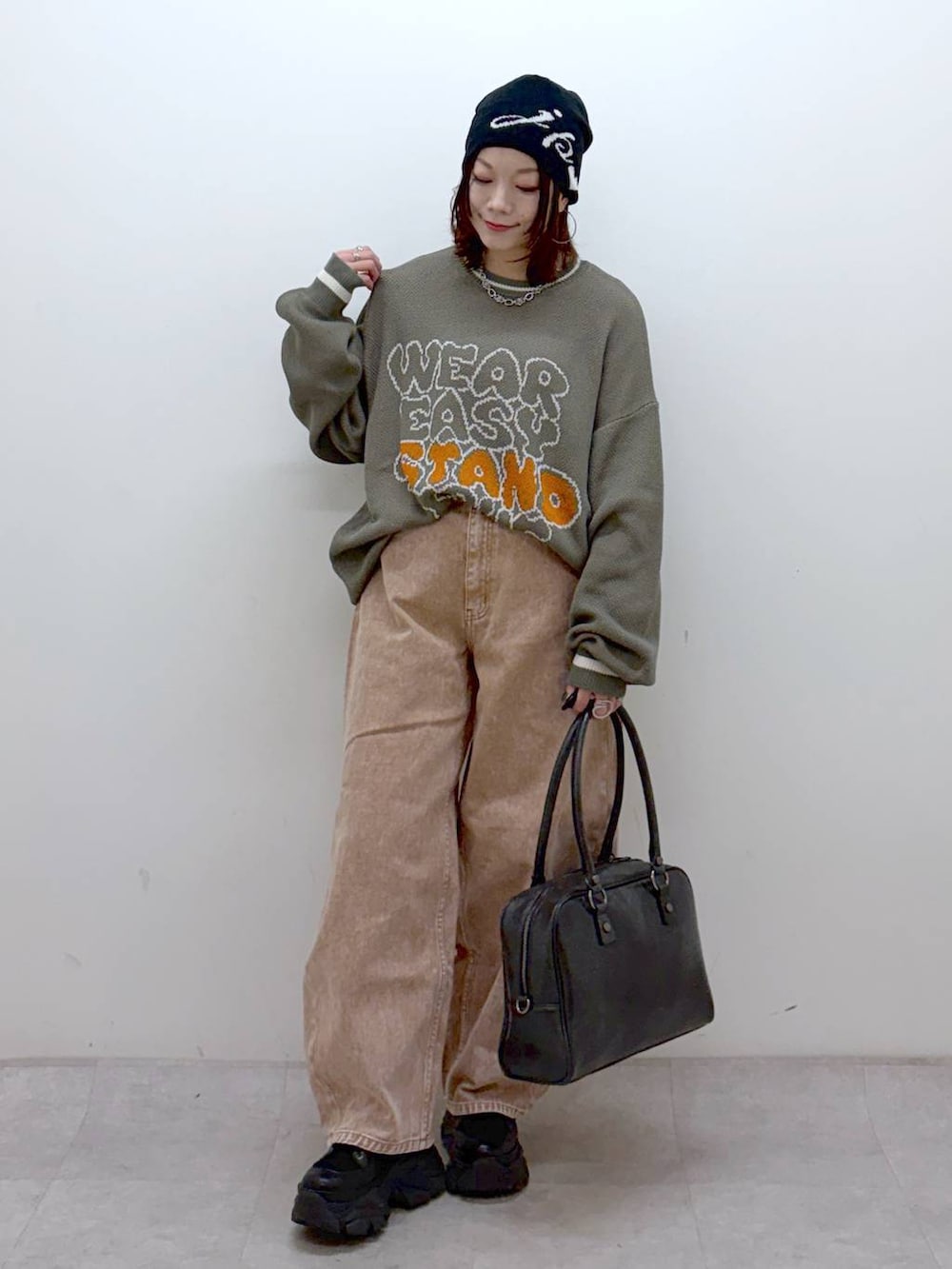 ブラック系のブーツ、ブラック系のボストンバッグ、ブラック系のブルゾンを着用したレディースの冬コーディネートの5枚目の写真