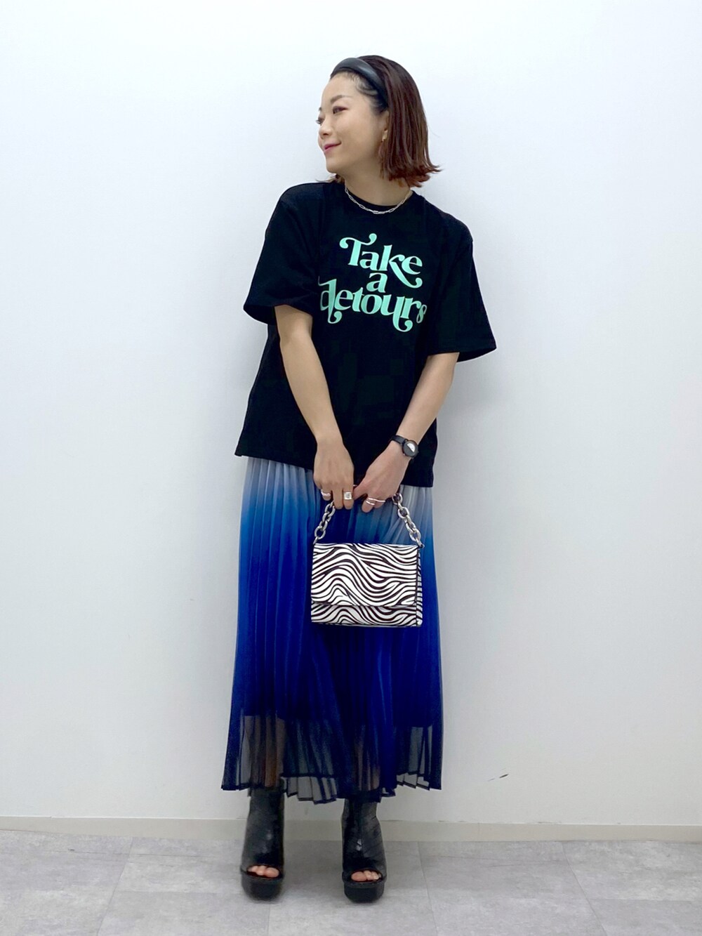 その他のショルダーバッグ、ブラック系のサンダル、ブルー系のスカートを着用したレディースの春コーディネートの2枚目の写真