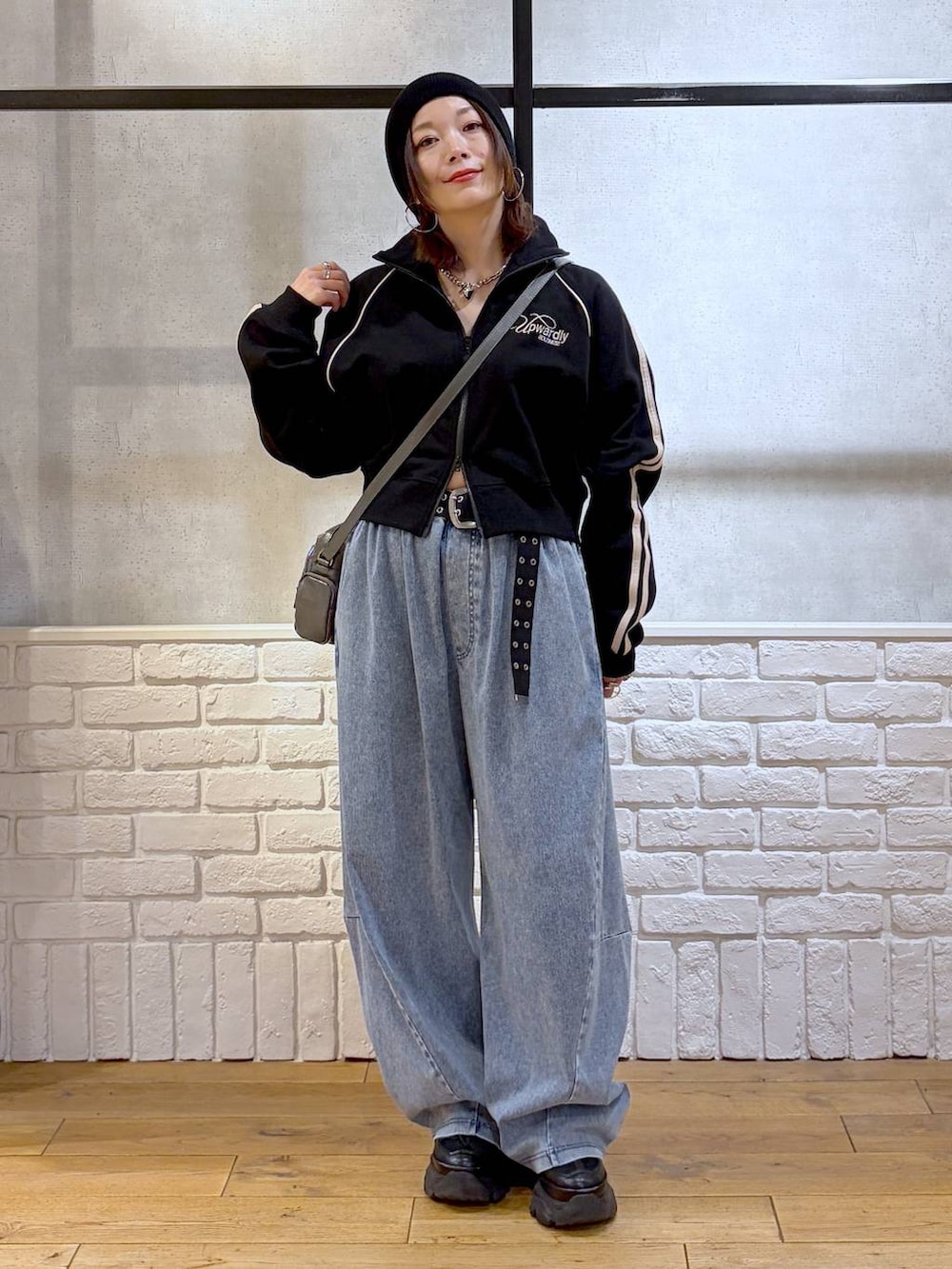 ブラック系のスニーカー、グレー系のショルダーバッグ、ブルー系のデニムパンツを着用したレディースの春コーディネートの9枚目の写真