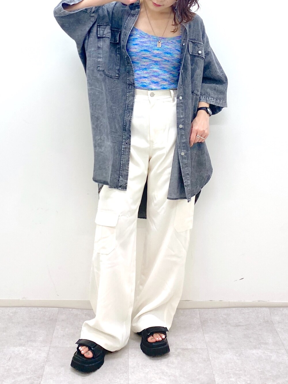 ホワイト系のカーゴパンツ、ブルー系のタンクトップ、ブラック系のサンダルを着用したレディースの夏コーディネートの5枚目の写真